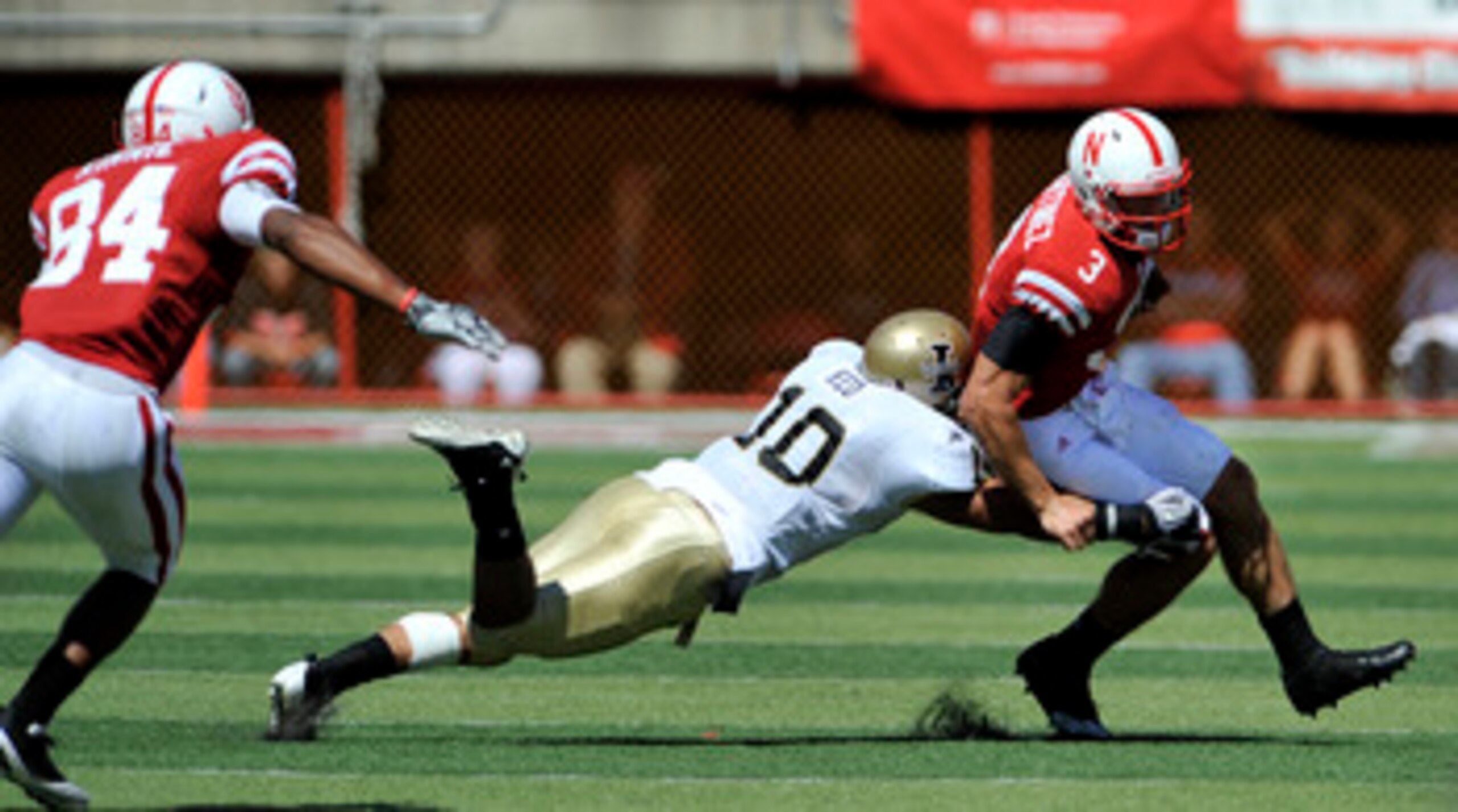 LINCOLN, NE - SEPTEMBER 11: Nebraska Cornhuskers quarterback Taylor Martinez #3 runs from Idaho Vandals safety Shiloh Keo #10 and Idaho Vandals cornerback Kenneth Patten #2 during second half action of their game at Memorial Stadium on September 4, 2010 i