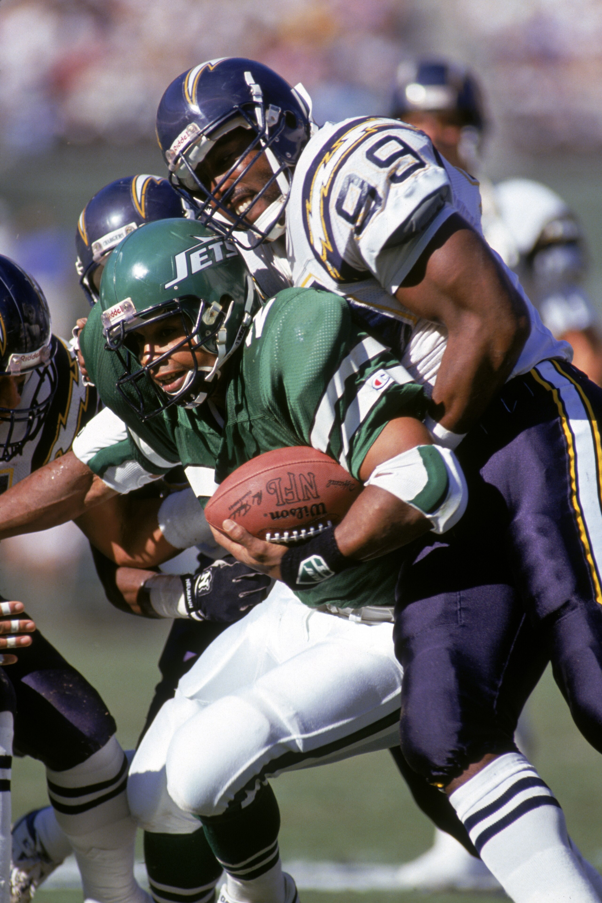 SAN DIEGO - DECEMBER 2:  Defensive end Lee Williams #99 of the San Diego Chargers tackles running back Freeman McNeil #24 of the New York Jets during a game at Jack Murphy Stadium on December 2, 1990 in San Diego, California.  The Chargers won 38-17.  (Ph