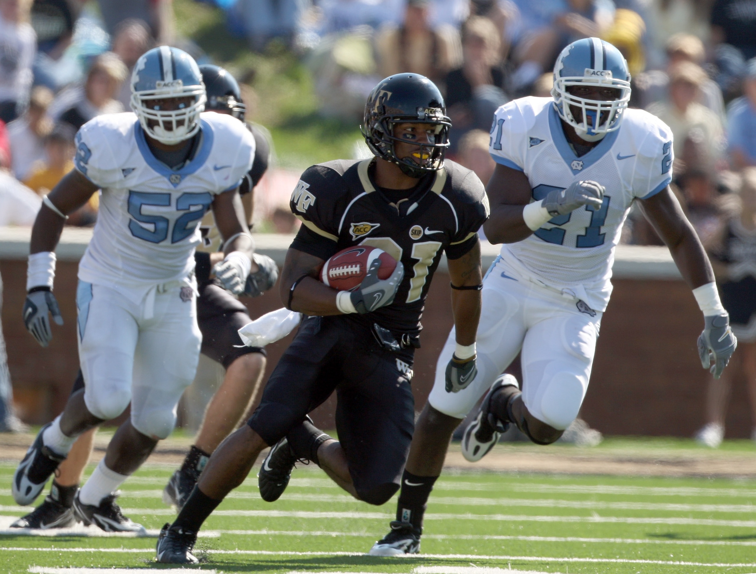 WINSTON SALEM, NC - OCTOBER 27:  Wide receiver Kenny Moore #21 of the Wake Forest Demon Deacons breaks away from Quan Sturdivant #52 and Martel Thatch #21 of the UNC Tar Heels during the ACC game at the Groves Stadium on October 27, 2007 in Winston Salem,