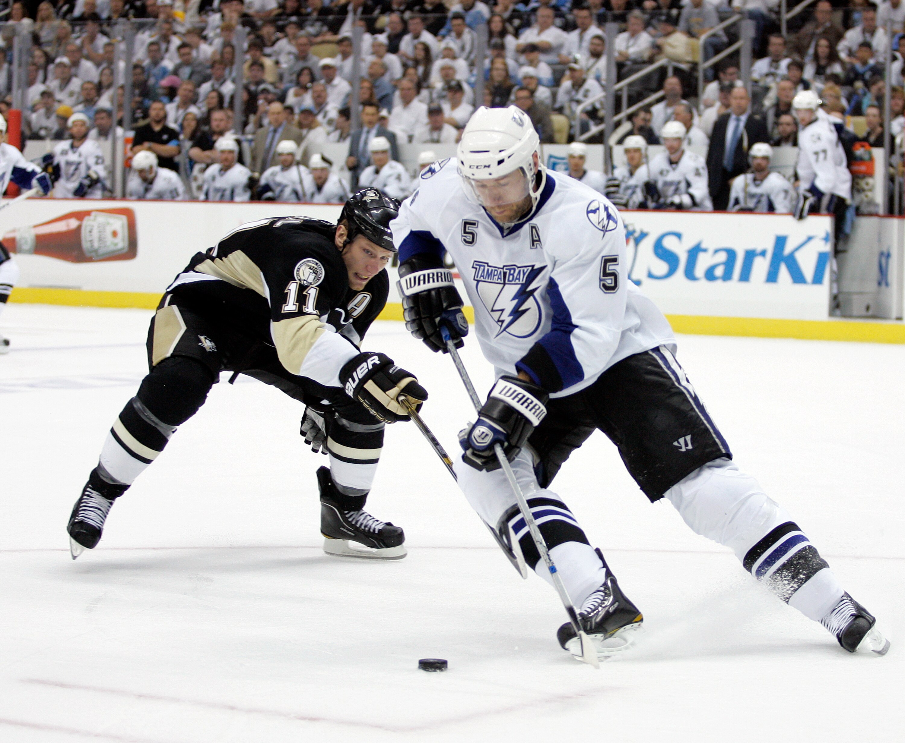 PITTSBURGH, PA - APRIL 23:  Mattias Ohlund #5 of the Tampa Bay Lightning handles the puck in front of Jordan Staal #11 of the Pittsburgh Penguins in Game Five of the Eastern Conference Quarterfinals during the 2011 NHL Stanley Cup Playoffs at Consol Energ