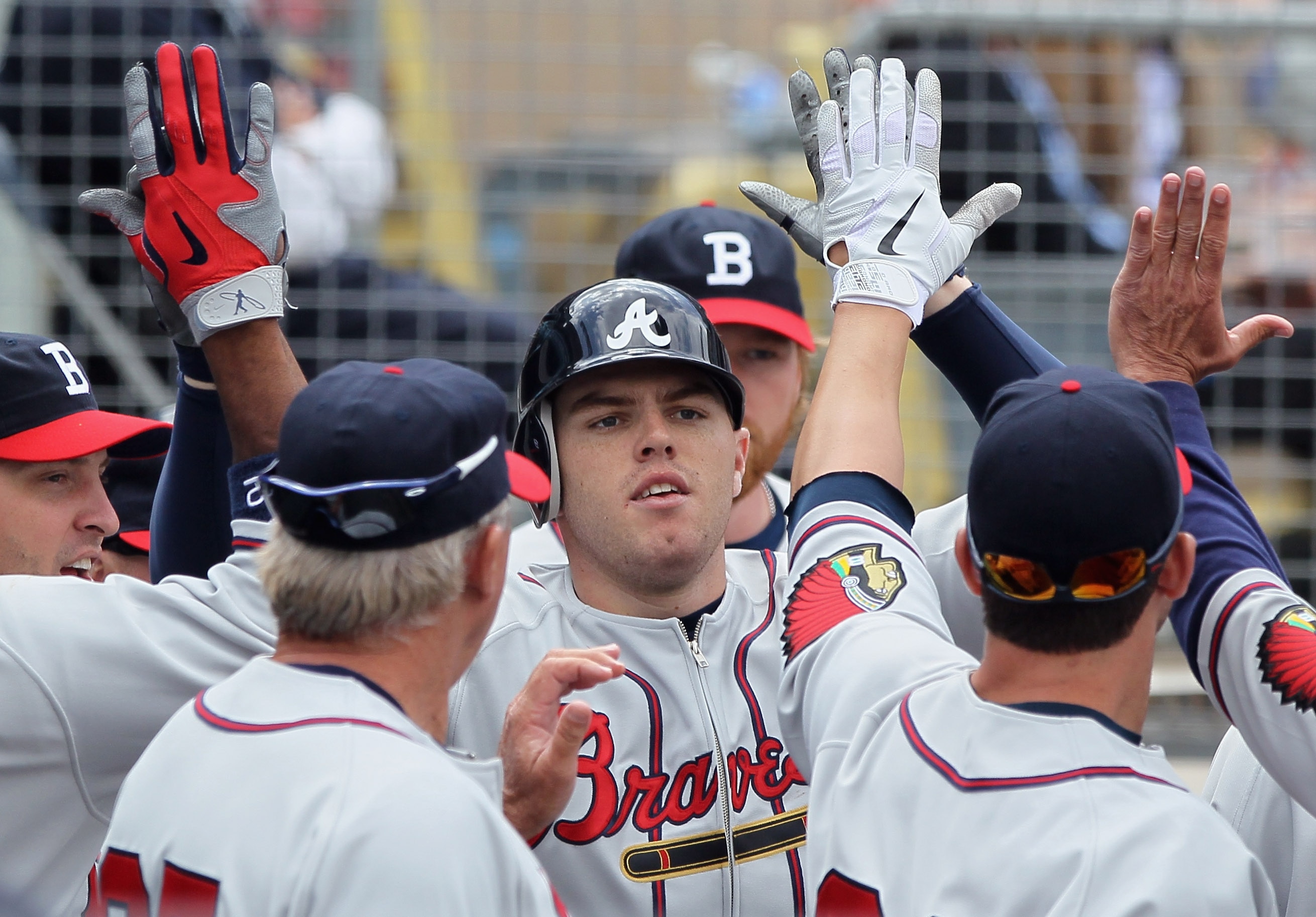LOS ANGELES, CA - APRIL 21:  Freddie Freeman #5 of the Atlanta Braves receives high fives in the dugout after hitting a solo home run in the fifth inning against the Los Angeles Dodgers at Dodger Stadium on April 21, 2011 in Los Angeles, California. The D