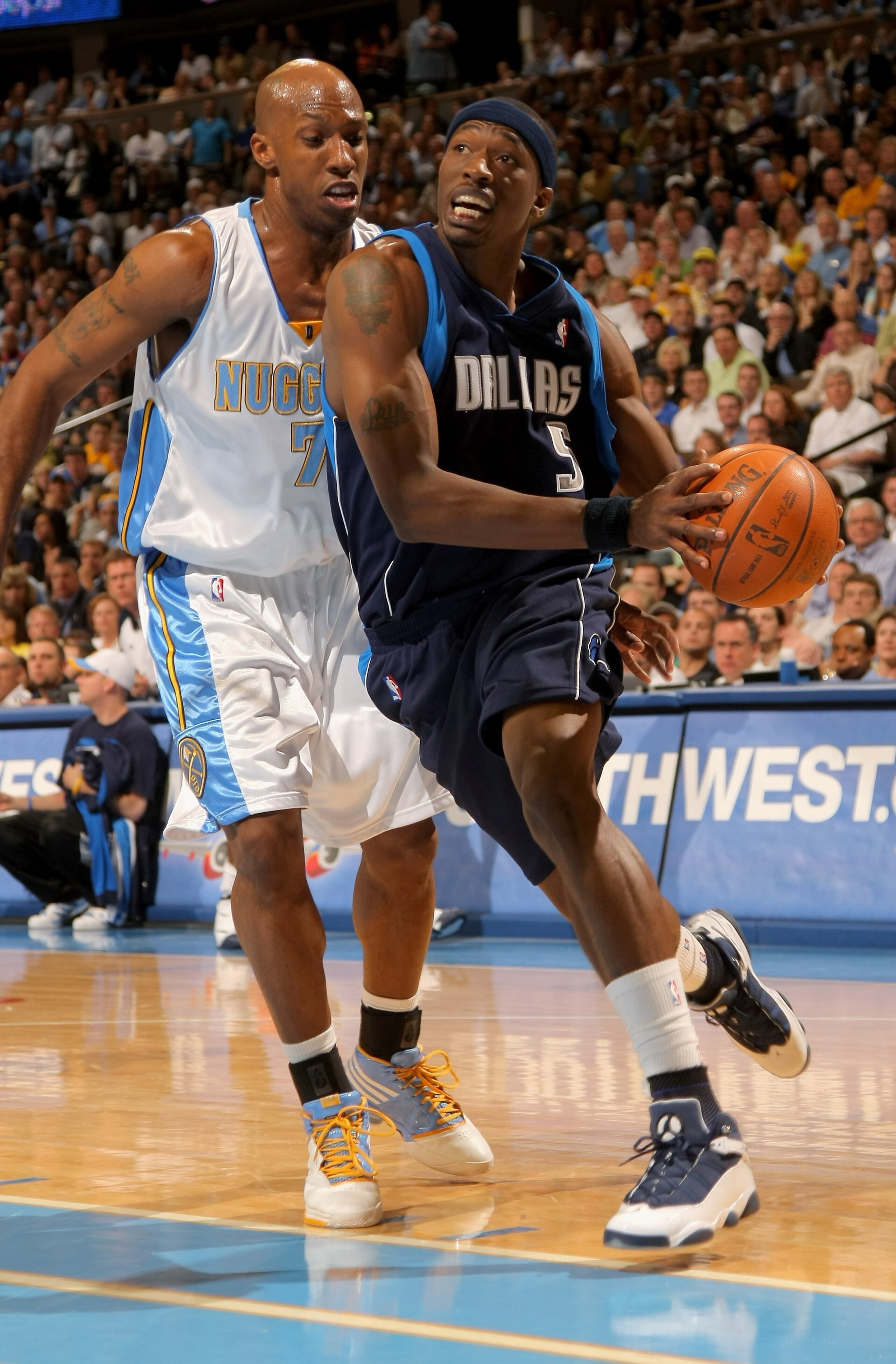 DENVER - MAY 13:  Josh Howard #5 of the Dallas Mavericks drives to the basket against Chauncey Billups #7 of the Denver Nuggets in Game Five of the Western Conference Semifinals during the 2009 NBA Playoffs at Pepsi Center on May 13, 2009 in Denver, Color