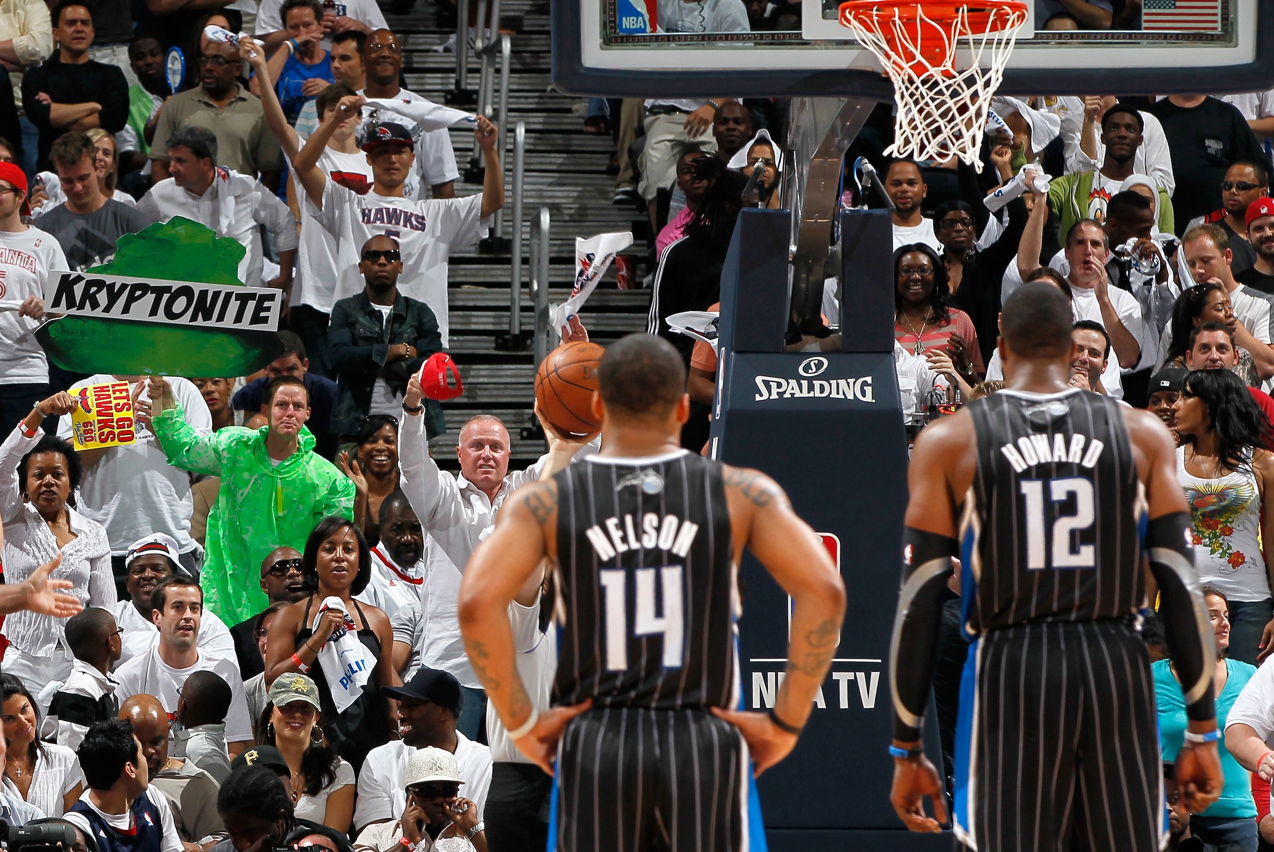 ATLANTA, GA - APRIL 24:  A fan dressed in neon green holding a green sign with the words 'Kryptonite' on it heckles Dwight Howard #12 of the Orlando Magic during a free throw against the Atlanta Hawks during Game Four of the Eastern Conference Quarterfina