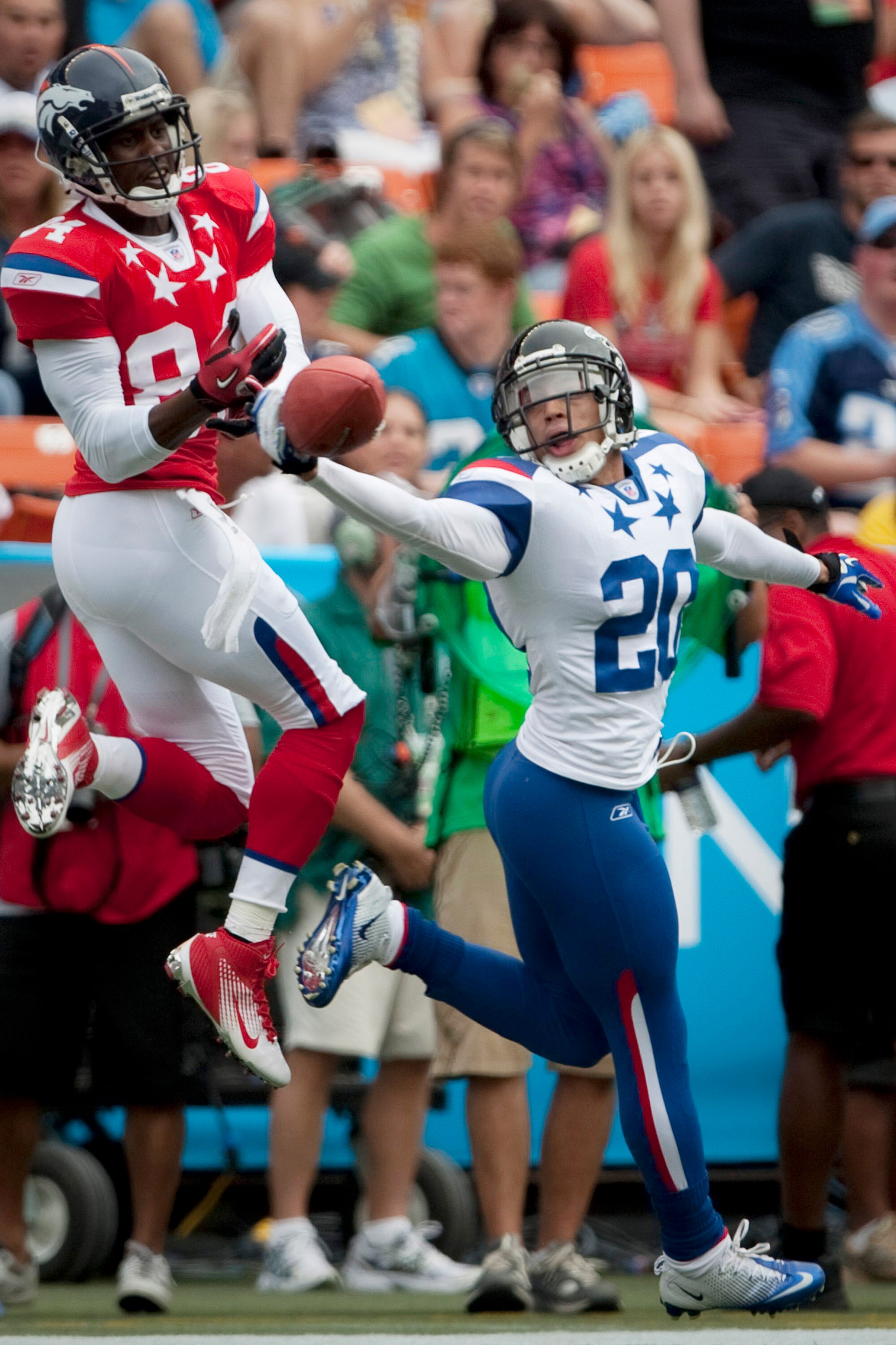 HONOLULU - JANUARY 30:  Brent Grimes, #20 of the Atlanta Falcons, tries to reel in a pass intended for Brandon Lloyd, #84 of the Denver Broncos, during the 2011 NFL Pro Bowl at Aloha Stadium on January 30, 2011 in Honolulu, Hawaii. NFC won 55-41 over the