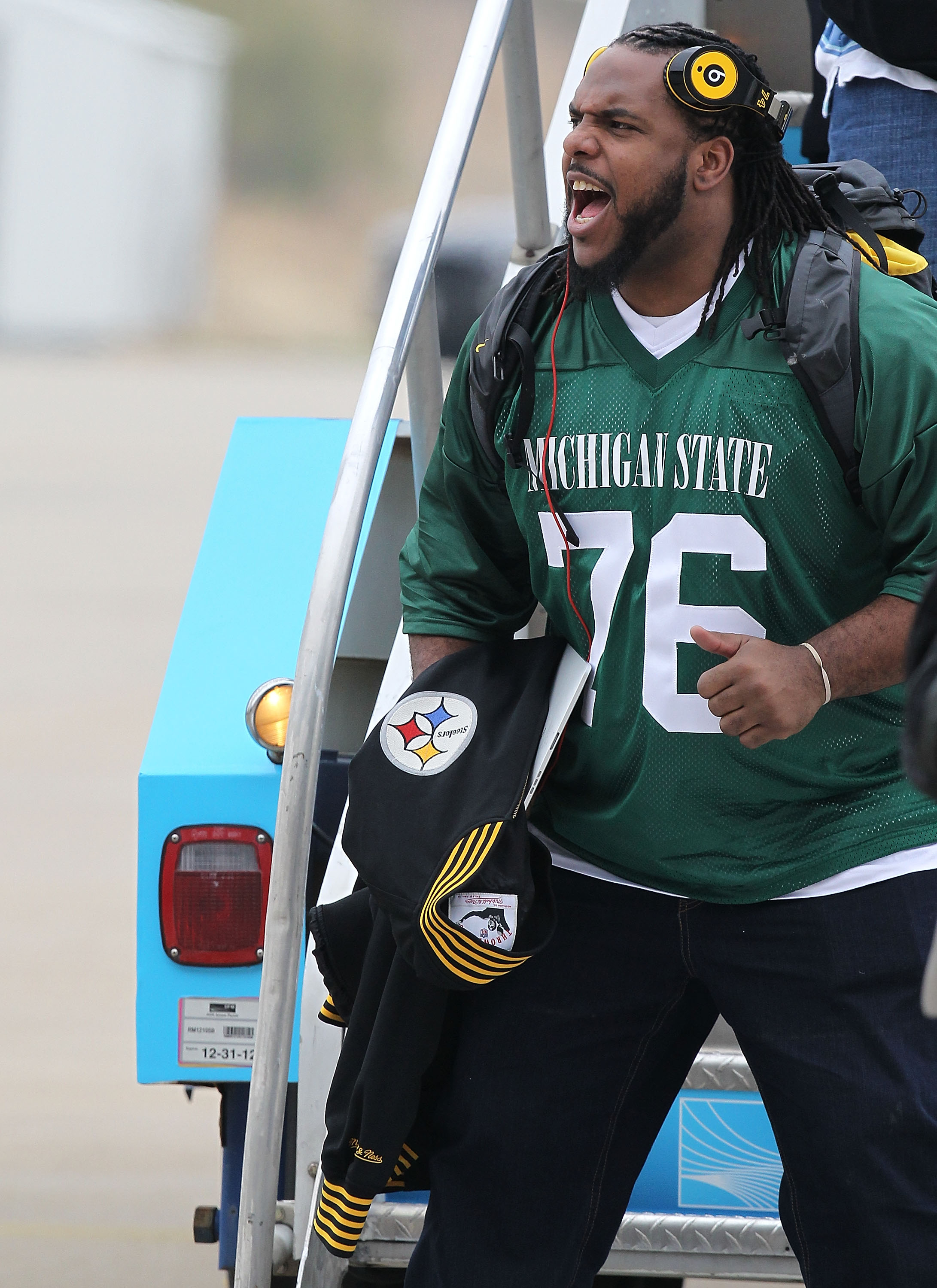 DALLAS, TX - JANUARY 31:  Willie Colon #74 of the Pittsburgh Steelers wears the Michigan State jersey of teammate Flozell Adams while arriving at Dallas Fort Worth International Airport on January 31, 2011 in Dallas, Texas.  The Pittsburgh Steelers will p
