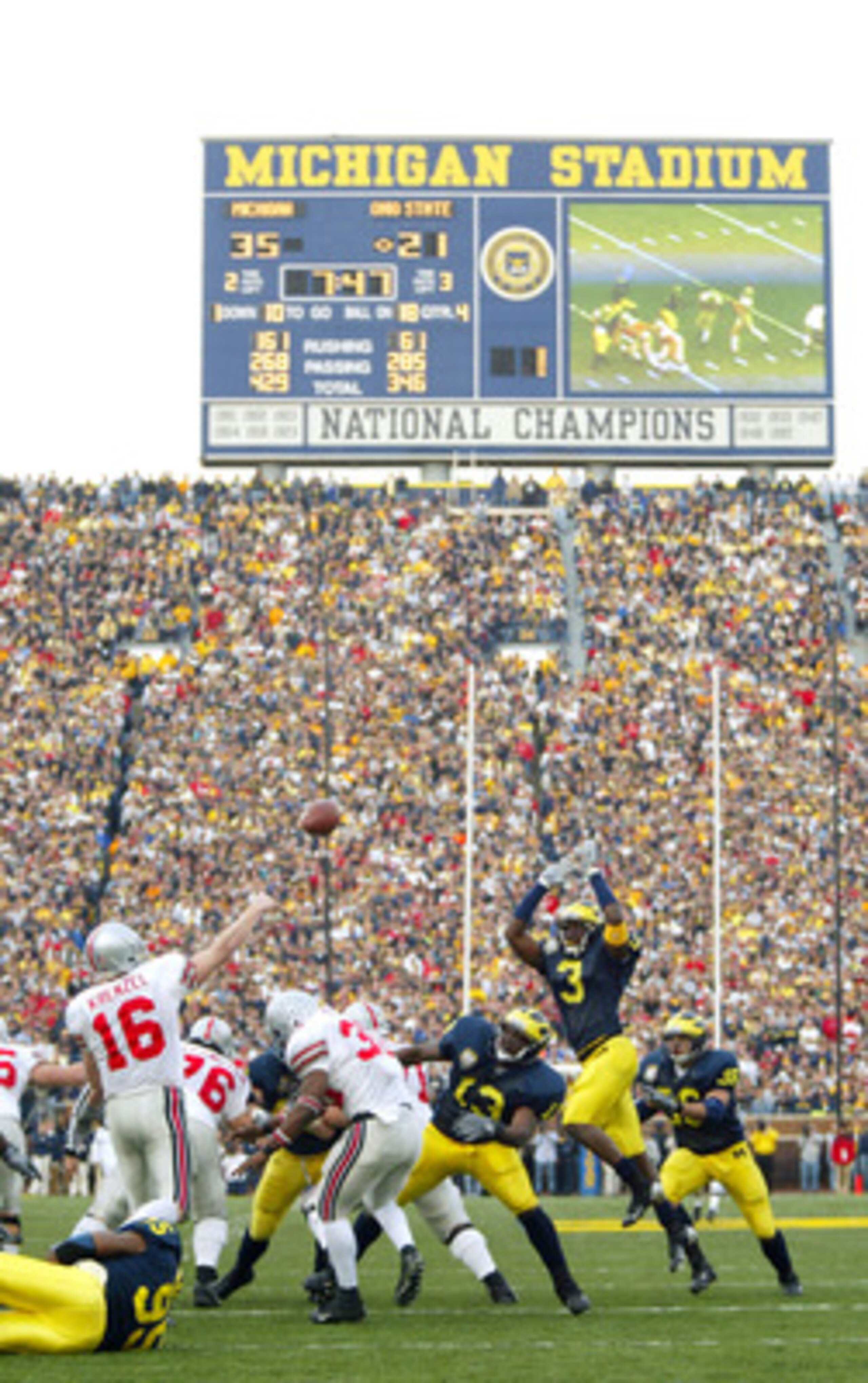 ANN ARBOR, MI - NOVEMBER 22:  Quarterback Craig Krenzel #16 of the Ohio State Buckeyes throws a pass as Alain Kashama #95 of the Michigan Wolverines holds onto him and Marlin Jackson #3 of Michigan jumps in attempt to bat the pass down in front of a recor