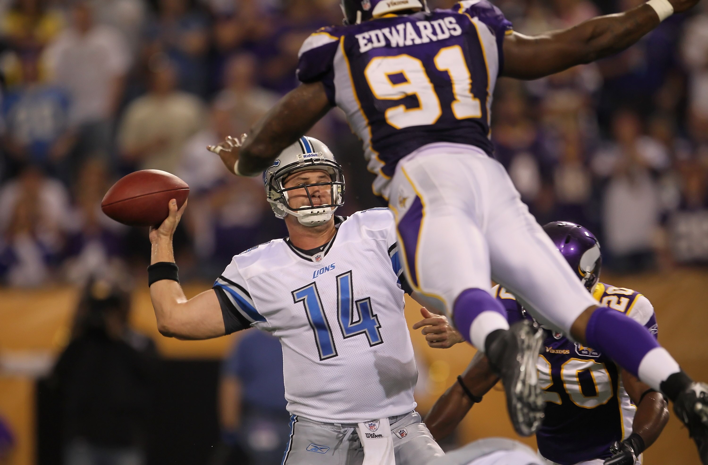 MINNEAPOLIS - SEPTEMBER 26:  Quarterback Shaun Hill #14 of the Detroit Lions is pressured by Ray Edwards #91 of the Minnesota Vikings during the second half at Hubert H. Humphrey Metrodome on September 26, 2010 in Minneapolis, Minnesota.  The Vikings defe