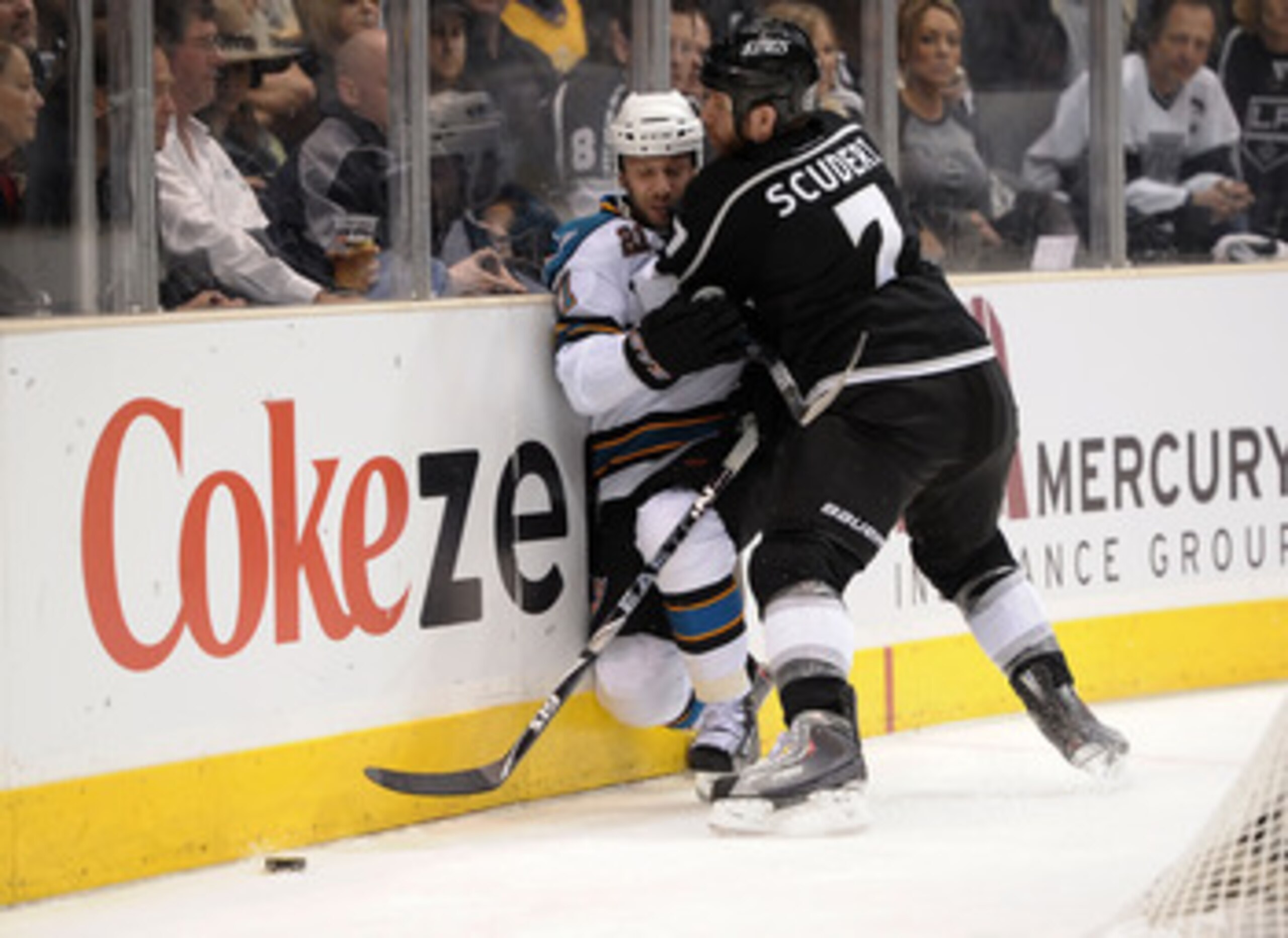 LOS ANGELES, CA - APRIL 21:  Scott Nichol #21 of the San Jose Sharks is checked by Rob Scuderi #7 of the Los Angeles Kings in the first period of game four of the Western Conference Quarterfinals during the 2011 NHL Stanley Cup Playoffs at Staples Center