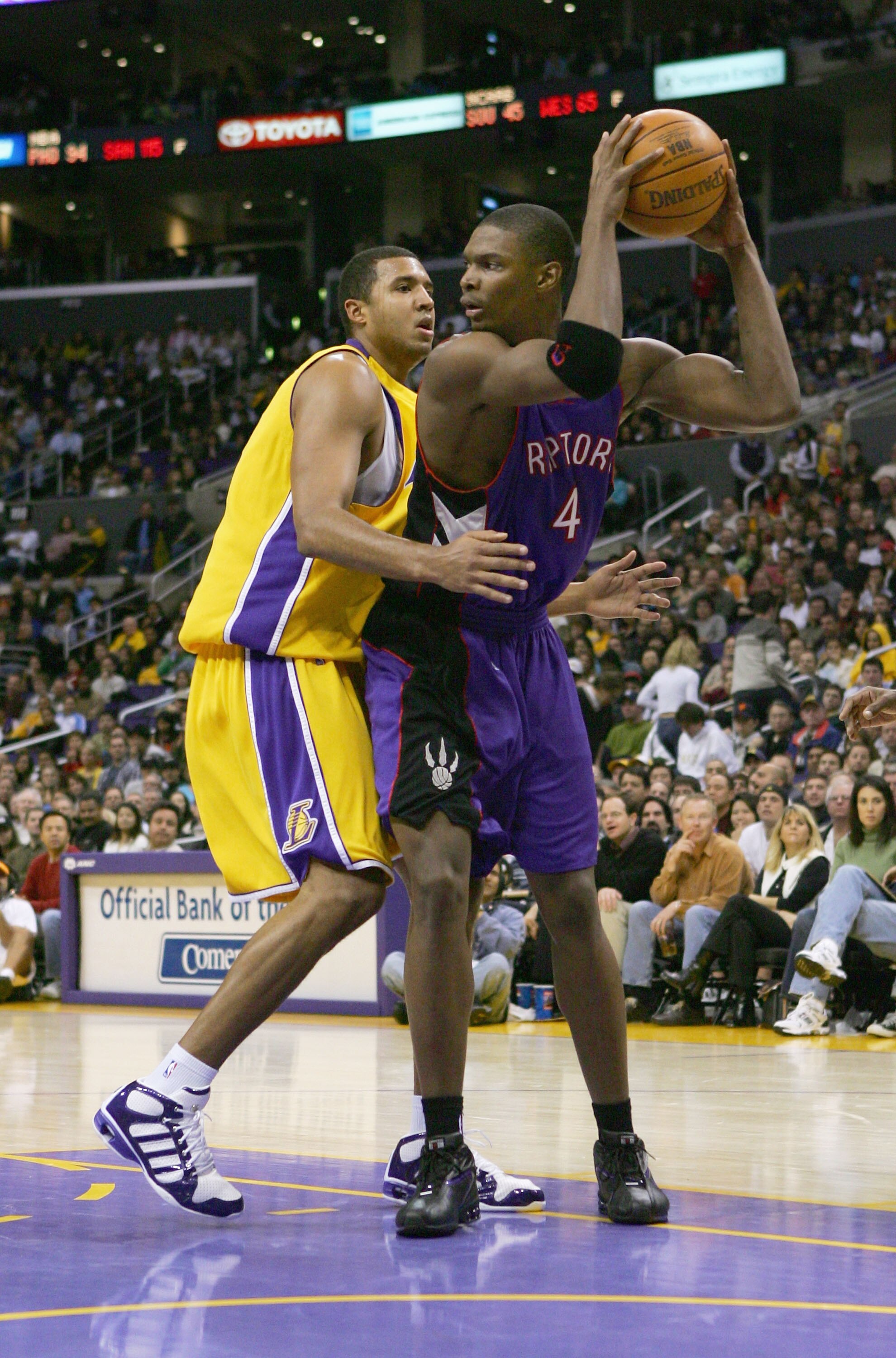 LOS ANGELES - DECEMBER 28:  Chris Bosh #4 of the Toronto Raptors looks to pass around Brian Cook #43 of the Los Angeles Lakers during the game on December 28, 2004 at Staples Center in Los Angeles, California.  The Lakers defeated the Raptors 117-99.  NOT