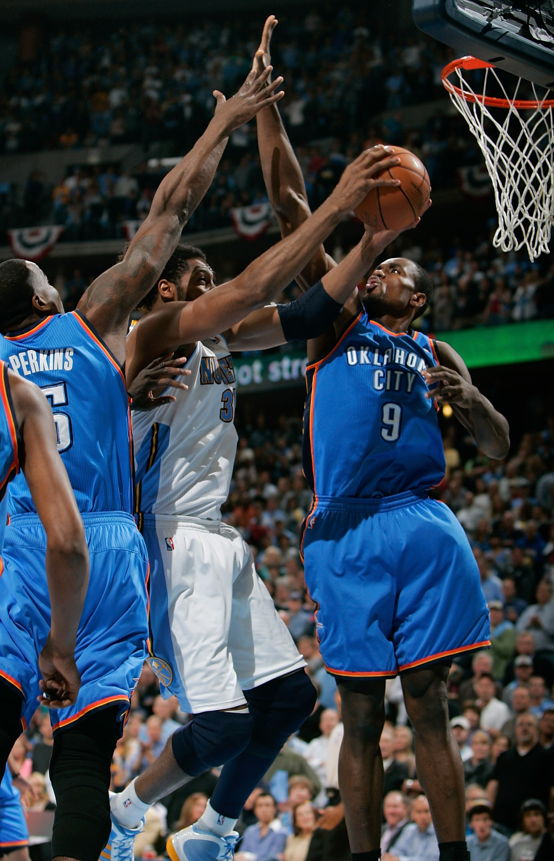 DENVER, CO - APRIL 23:  Nene #31 of the Denver Nuggets goes up for a shot against Kendrick Perkins #5 and Serge Ibaka #9 of the Oklahoma City Thunder in Game Three of the Western Conference Quarterfinals in the 2011 NBA Playoffs at Pepsi Center on April 2