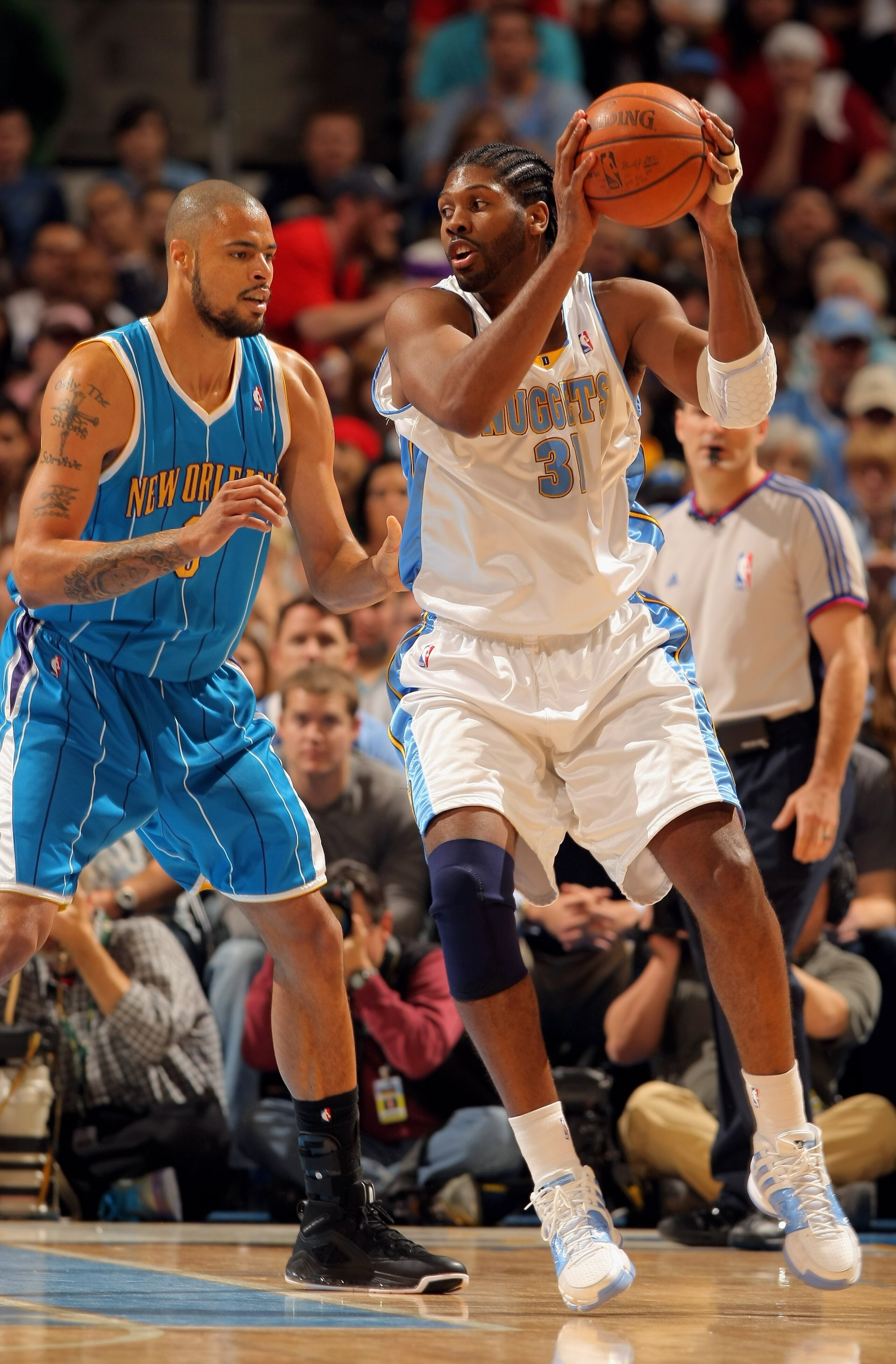 DENVER - APRIL 19:  Nene #31 of the Denver Nuggets controls the ball as Tyson Chandler #6 of the New Orleans Hornets defends in Game One of the Western Conference Quarterfinals during the 2009 NBA Playoffs at Pepsi Center on April 19, 2009 in Denver, Colo