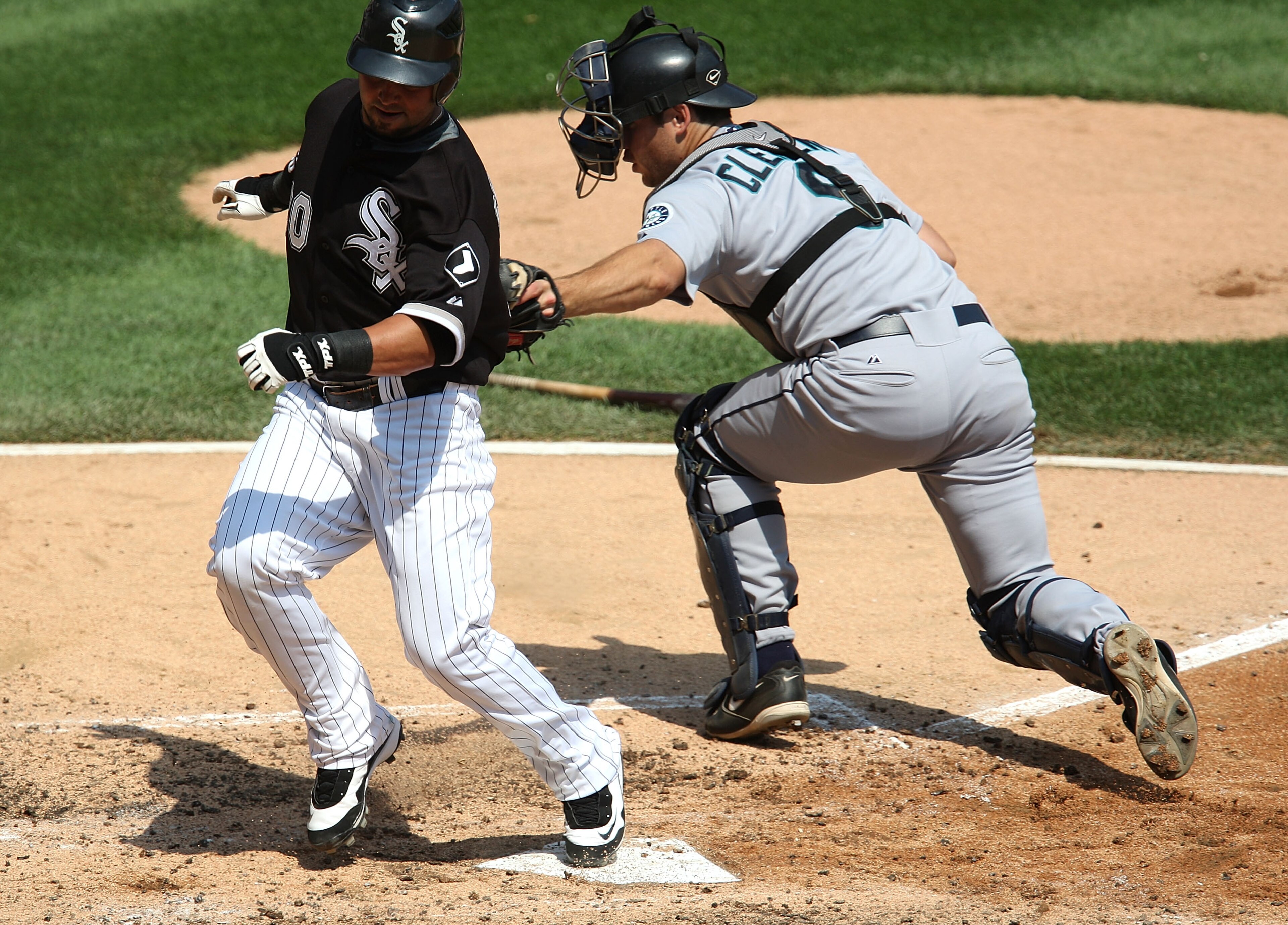 CHICAGO - AUGUST 20: Nick Swisher #30 of the Chicago White Sox avoids the tag by Jeff Clement #9 of the Seattle Mariners to score a run in the 3rd inning on August 20, 2008 at U.S. Cellular Field in Chicago, Illinois. The White Sox defeated the MAriners 1