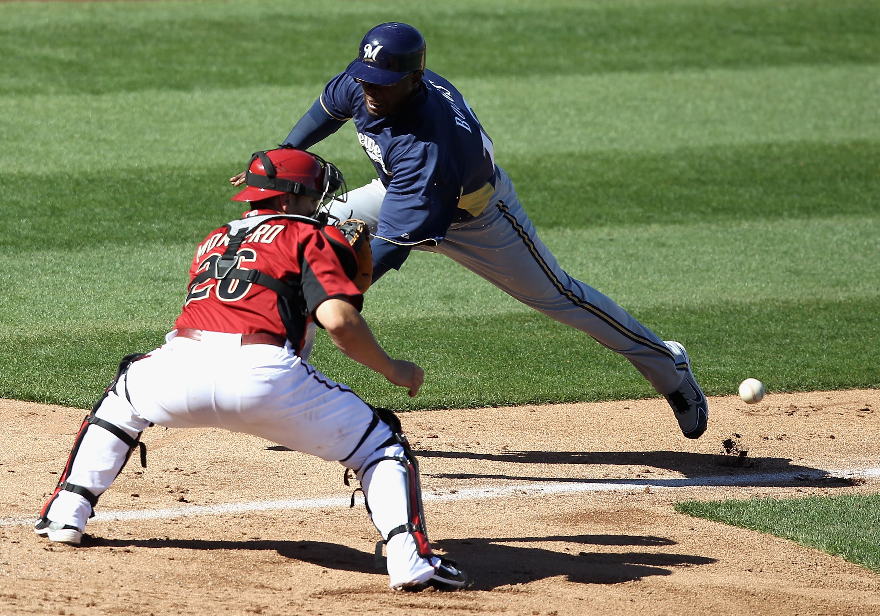 SCOTTSDALE, AZ - MARCH 09:  Brandon Boggs #12 of the Milwaukee Brewers safely scores a run past catcher Miguel Montero #26 of the Arizona Diamondbacks during the fifth inning of the spring training game at Salt River Fields at Talking Stick on March 9, 20