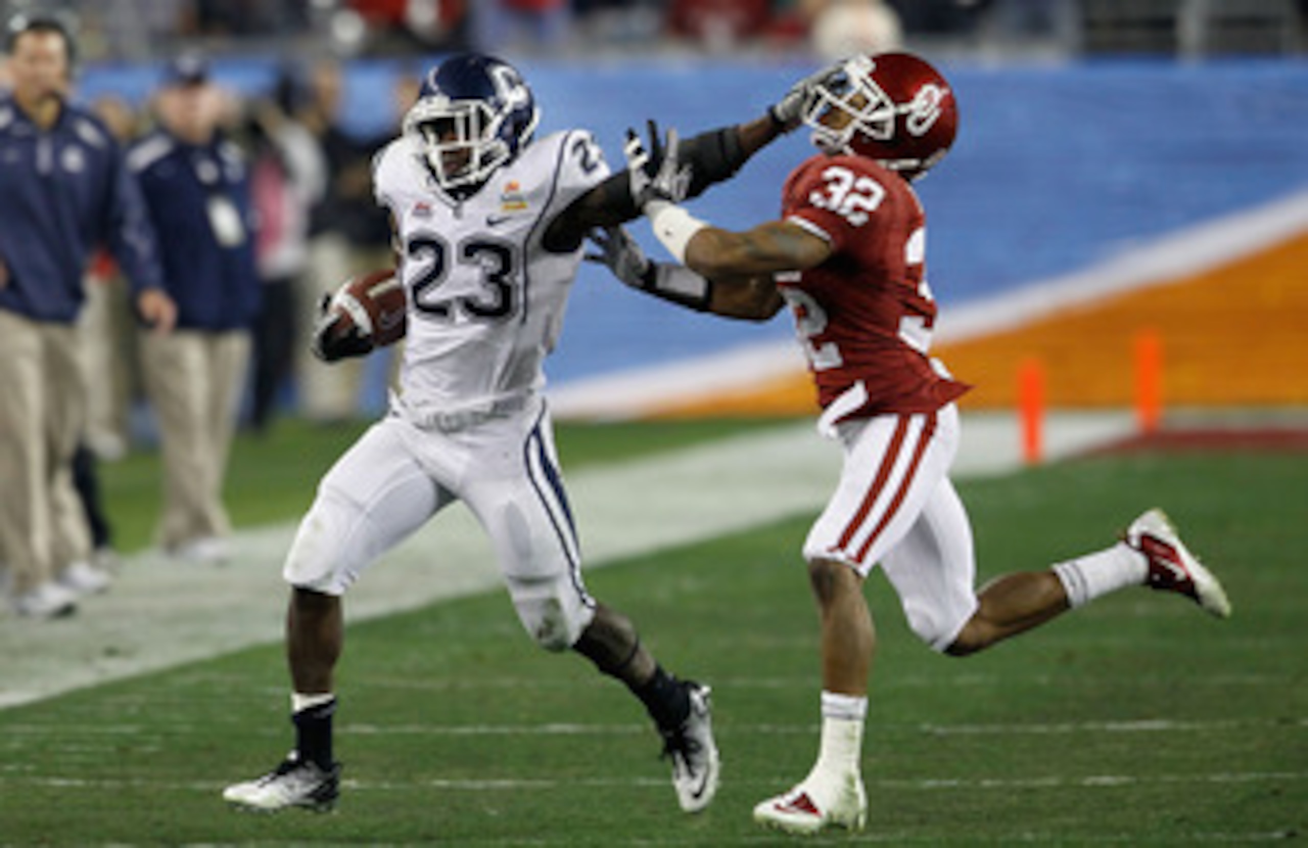GLENDALE, AZ - JANUARY 01: Jordan Todman #23 of the Connecticut Huskies stiff arms Jamell Fleming #32 of the Oklahoma Sooners in the second quarter during the Tostitos Fiesta Bowl at the Universtity of Phoenix Stadium on January 1, 2011 in Glendale, Ariz GLENDALE, AZ - JANUARY 01: Jordan Todman #23 of the Connecticut Huskies stiff arms Jamell Fleming #32 of the Oklahoma Sooners in the second quarter during the Tostitos Fiesta Bowl at the Universtity of Phoenix Stadium on January 1, 2011 in Glendale, Ariz