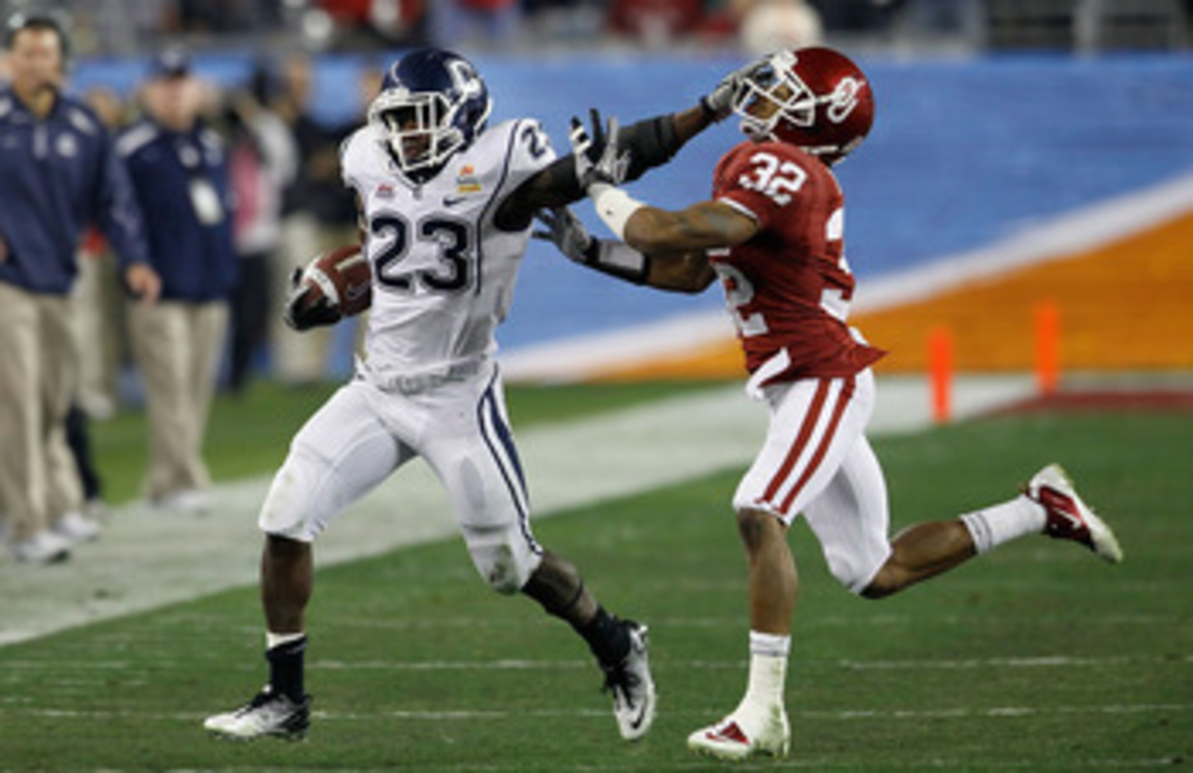 GLENDALE, AZ - JANUARY 01: Jordan Todman #23 of the Connecticut Huskies stiff arms Jamell Fleming #32 of the Oklahoma Sooners in the second quarter during the Tostitos Fiesta Bowl at the Universtity of Phoenix Stadium on January 1, 2011 in Glendale, Ariz GLENDALE, AZ - JANUARY 01: Jordan Todman #23 of the Connecticut Huskies stiff arms Jamell Fleming #32 of the Oklahoma Sooners in the second quarter during the Tostitos Fiesta Bowl at the Universtity of Phoenix Stadium on January 1, 2011 in Glendale, Ariz