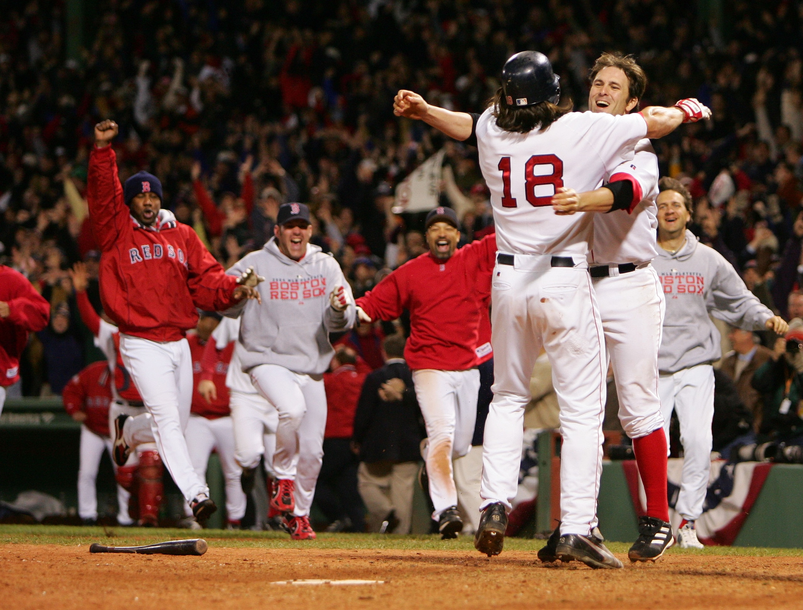 BOSTON - OCTOBER 18:  Johnny Damon #18 of the Boston Red Sox  celebrates with teammate Doug Mientkiewicz #13 and the rest of the Red Sox team after scoring the game winning run on a single hit by David Ortiz #34 in the fourteenth inning to defeat the New