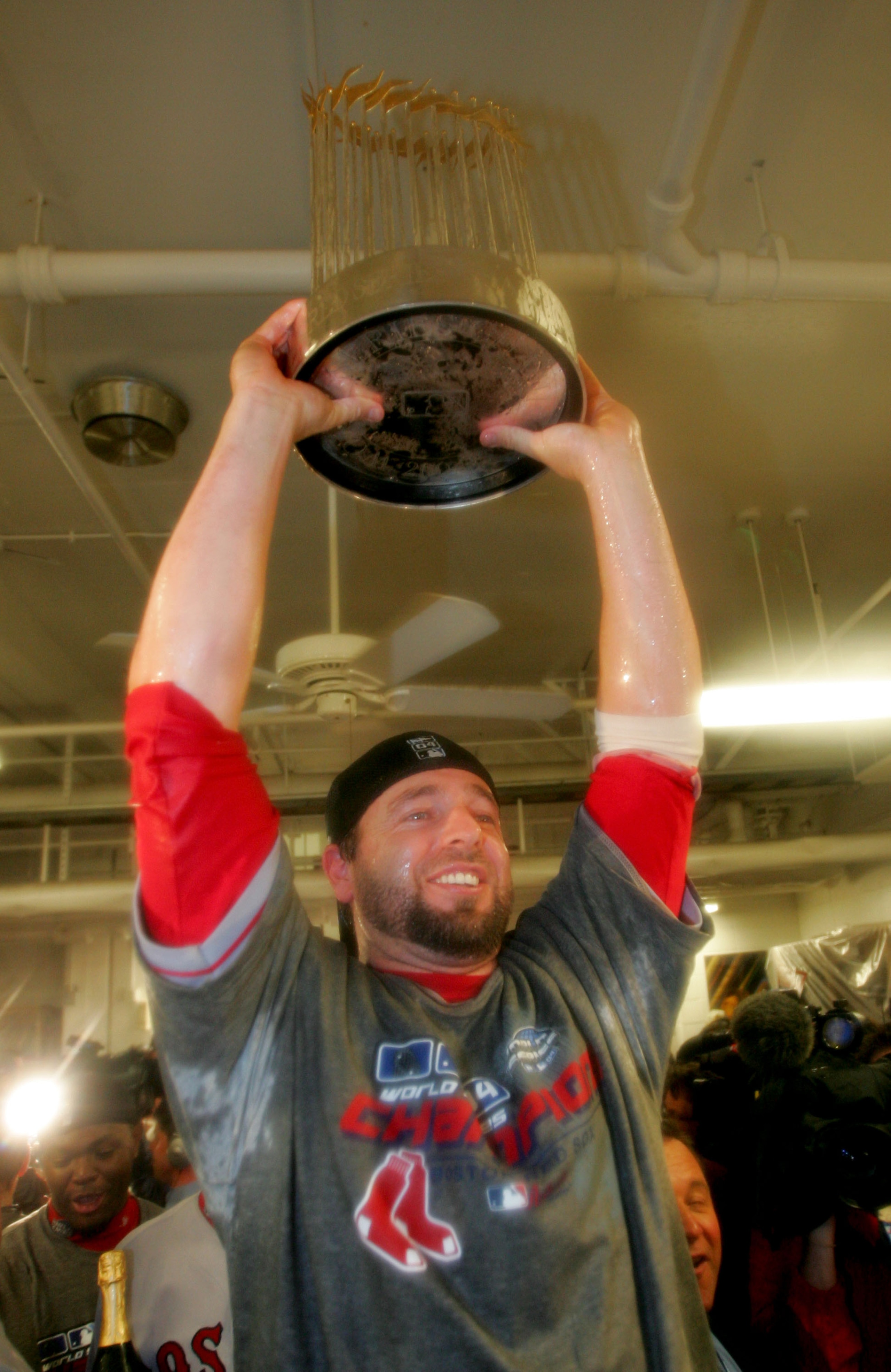 ST LOUIS - OCTOBER 27:  Kevin Millar #15 of the Boston Red Sox celebrates with the Championship trophy in the locker room after defeating the St. Louis Cardinals 3-0 to win game four of the World Series on October 27, 2004 at Busch Stadium in St. Louis, M