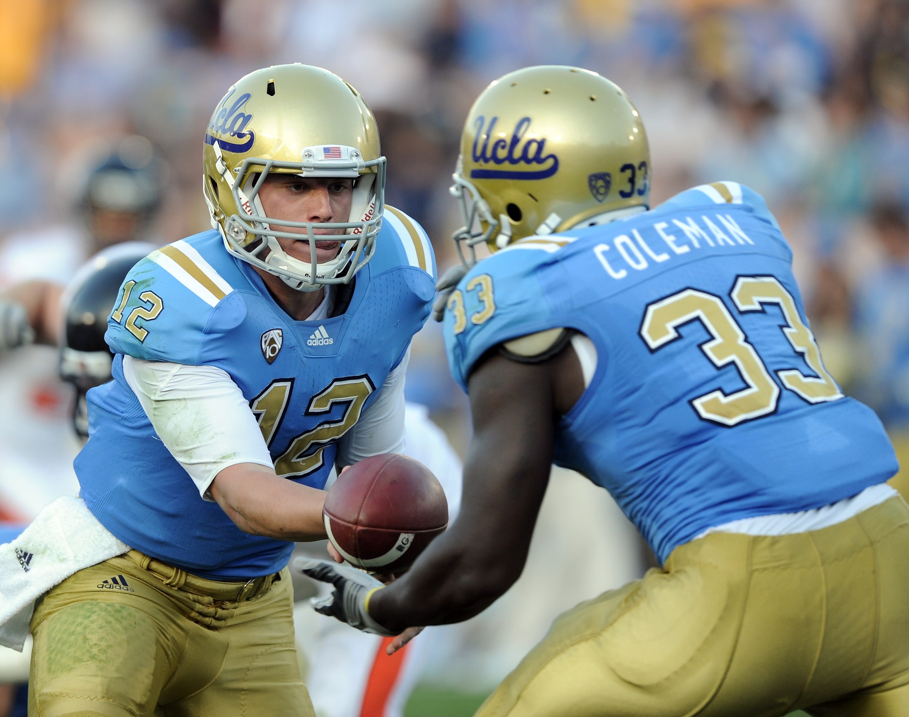 PASADENA, CA - NOVEMBER 06:  Richard Brehaut #12 of the UCLA Bruins handsoff to Derrick Coleman #33 against the Oregon State Beavers at the Rose Bowl on November 6, 2010 in Pasadena, California.  (Photo by Harry How/Getty Images)