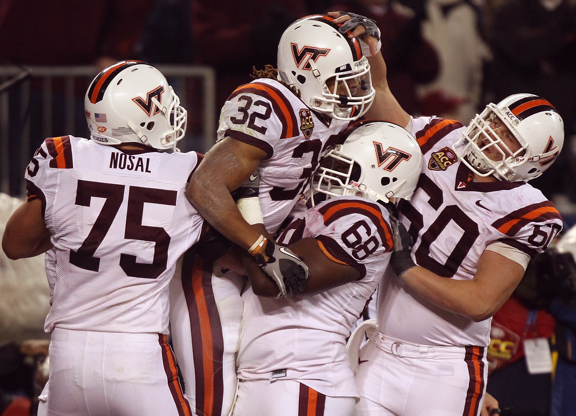 CHARLOTTE, NC - DECEMBER 04:  Darren Evans #32 of the Virginia Tech Hokies celebrates with teammates Greg Nosal #75, Jaymes Brooks #68 and Beau Warren #60 after scoring a touchdown during their game against the Florida State Seminoles at Bank of America S