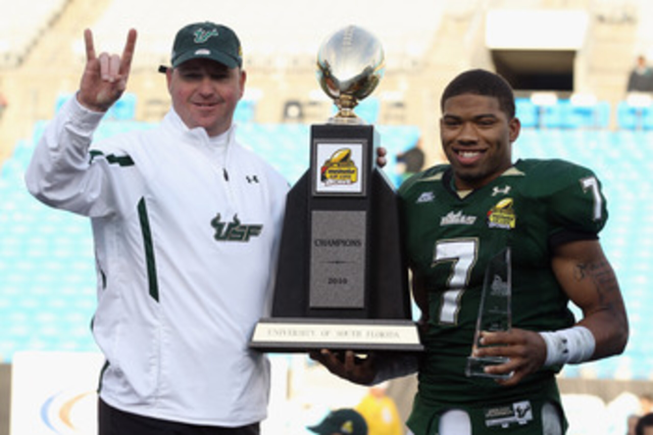 CHARLOTTE, NC - DECEMBER 31: Head coach Skip Holtz stands with MVP B.J. Daniels #7 of the USF Bulls after a 31-26 victory over the Clemson Tigers at Bank of America Stadium on December 31, 2010 in Charlotte, North Carolina. (Photo by Streeter Lecka/Gett CHARLOTTE, NC - DECEMBER 31: Head coach Skip Holtz stands with MVP B.J. Daniels #7 of the USF Bulls after a 31-26 victory over the Clemson Tigers at Bank of America Stadium on December 31, 2010 in Charlotte, North Carolina. (Photo by Streeter Lecka/Gett