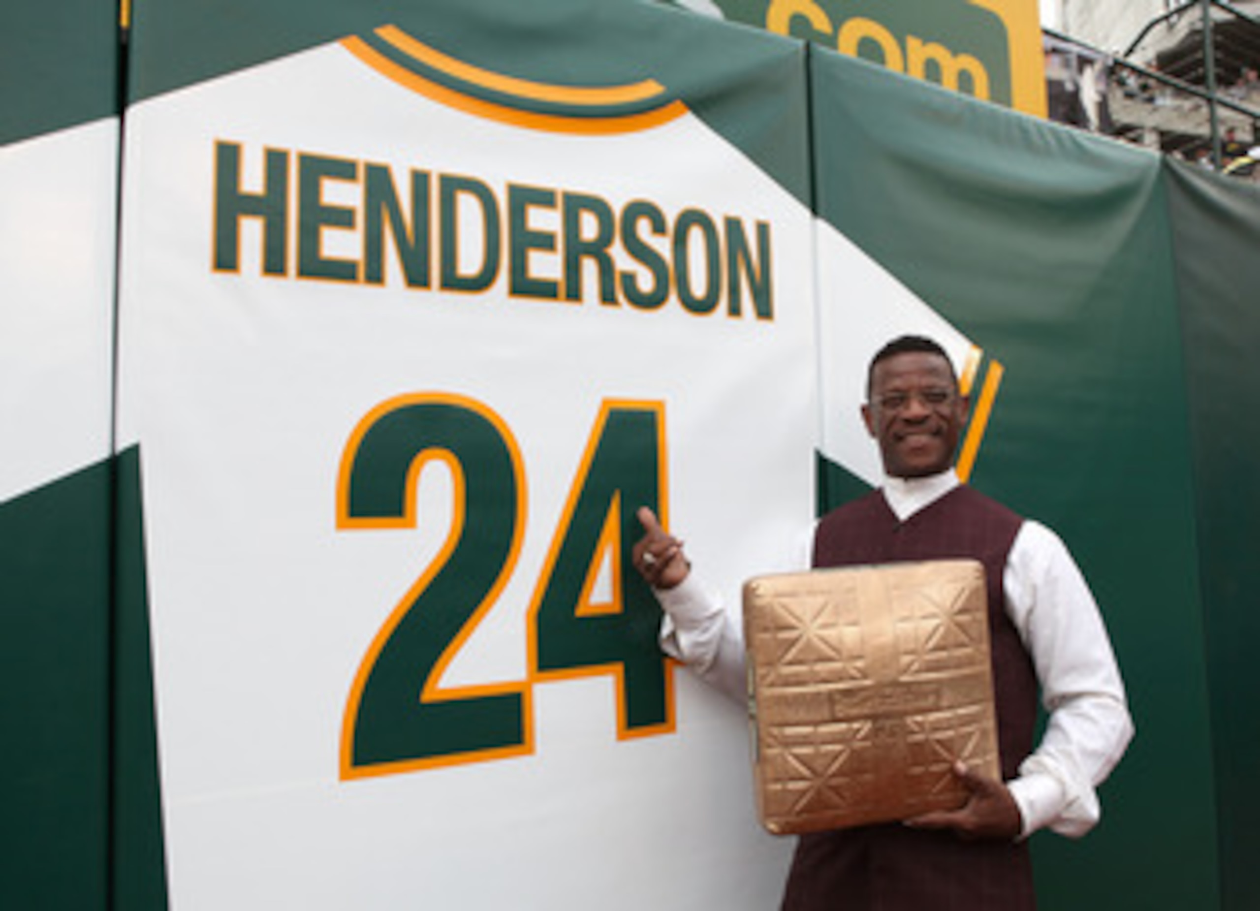 OAKLAND, CA - AUGUST 01:  Hall of Fame baseball player Rickey Henderson stands in front of his retired jersey during a ceremony to retire his number 24 by the Oakland Athletics before the start of the game against the Toronto Blue Jays August 1, 2009 at t