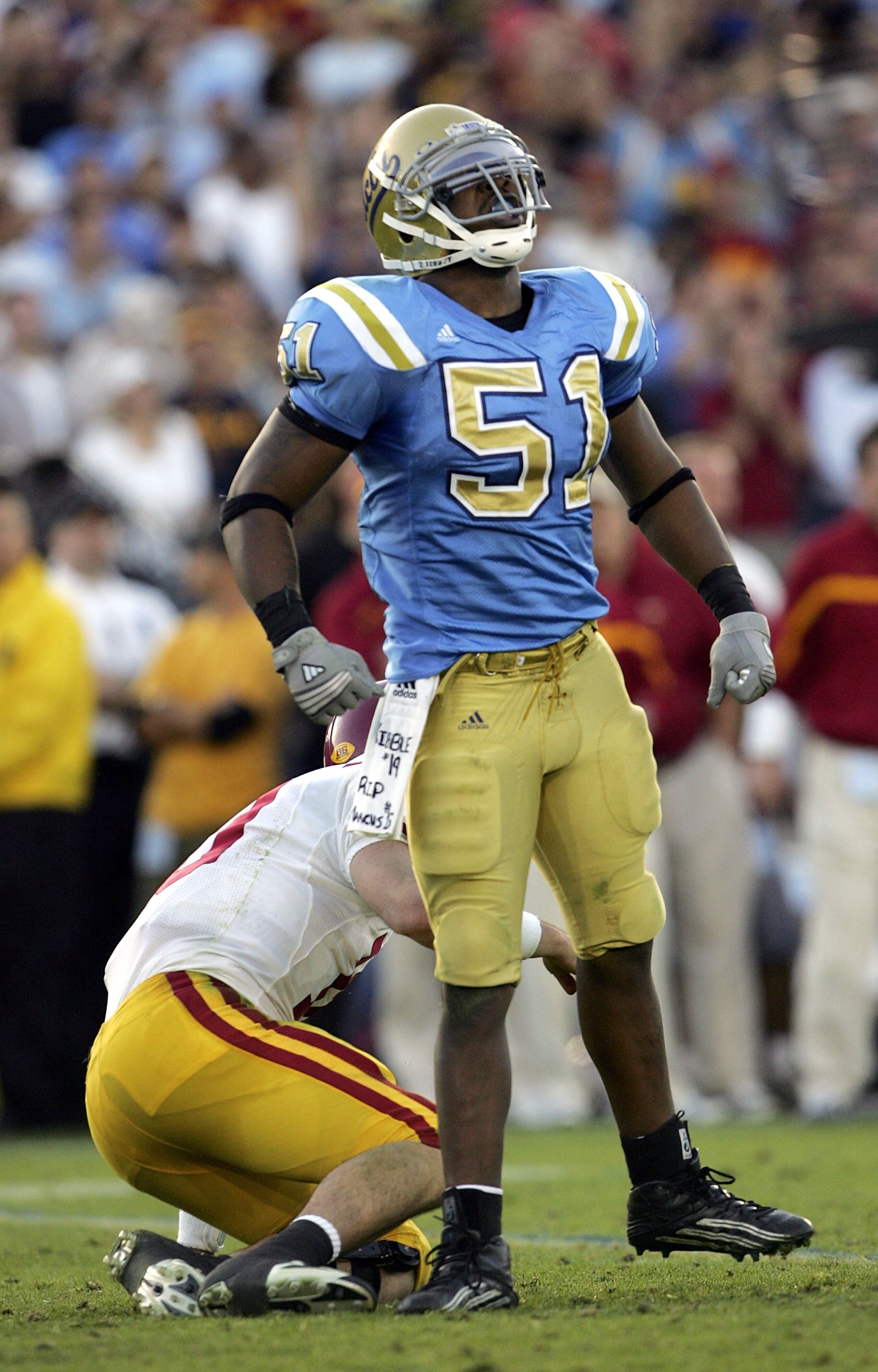 PASADENA, CA - DECEMBER 02:  Linebacker Reggie Carter #51 of the UCLA Bruins celebrates a sack as quarterback John David Booty #10 of the USC Trojans gets up off the ground on December 2, 2006 at the Rose Bowl in Pasadena, California.   (Photo by Stephen