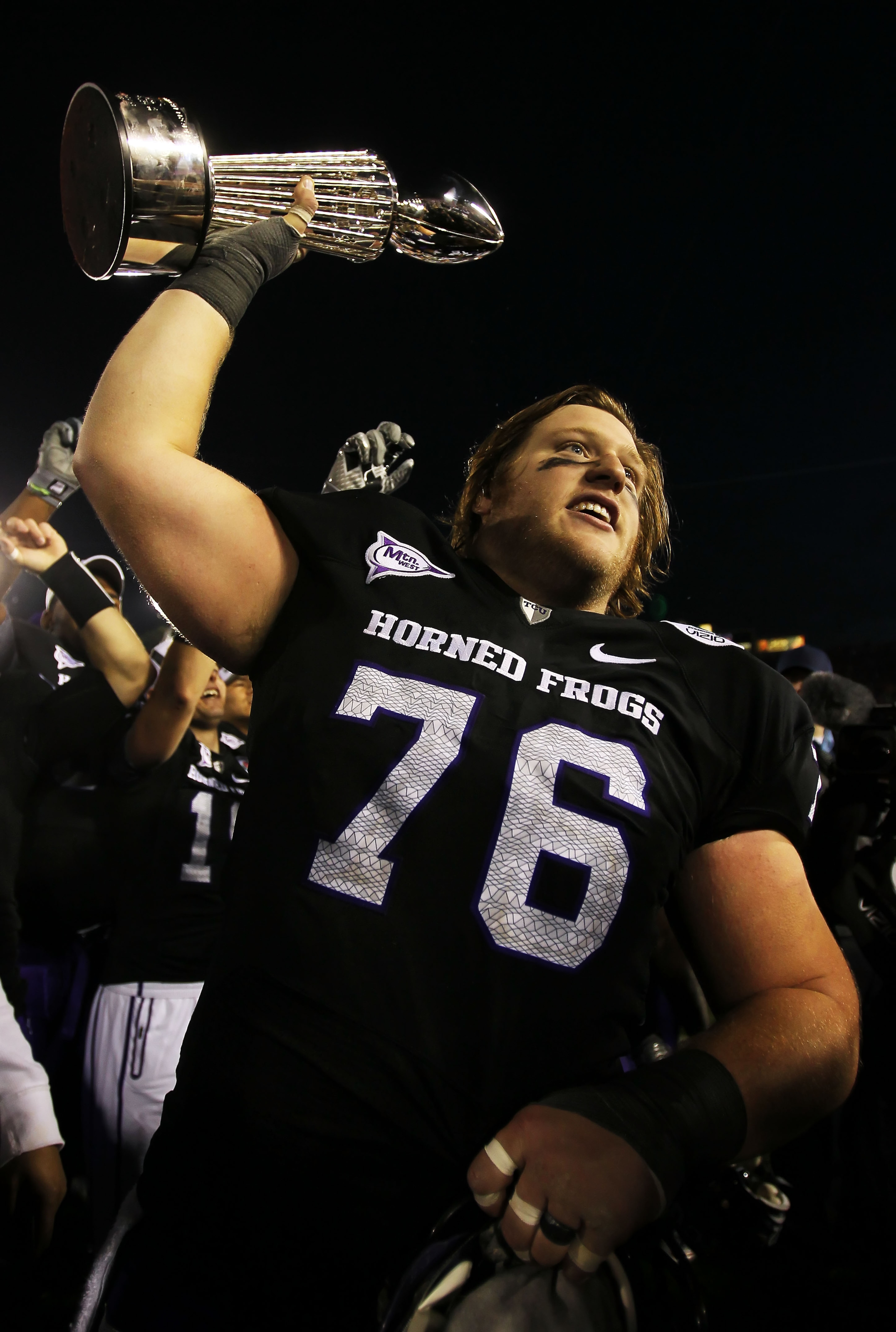PASADENA, CA - JANUARY 01:  Center Jake Kirkpatrick #76 of the TCU Horned Frogs celebrates with the Rose Bowl Championship Trophy after defeating the Wisconsin Badgers 21-19 in the 97th Rose Bowl game on January 1, 2011 in Pasadena, California.  (Photo by