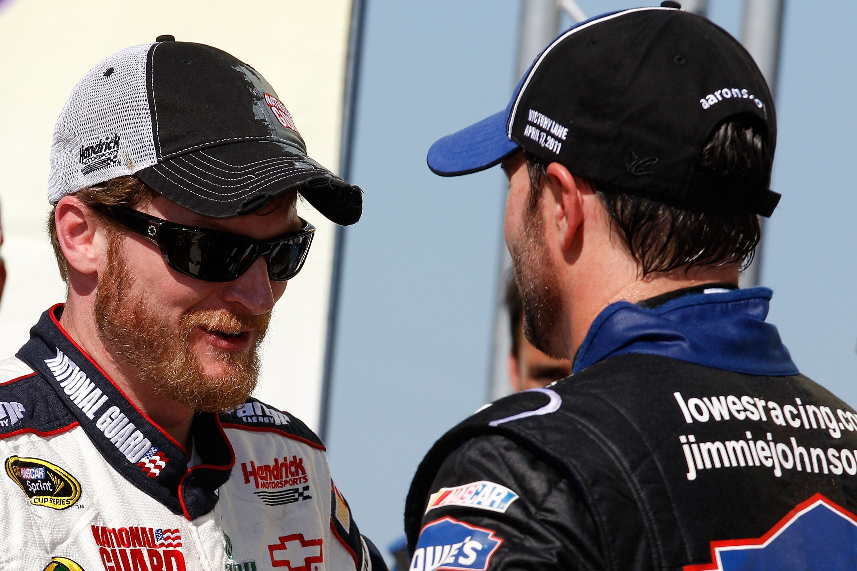 TALLADEGA, AL - APRIL 17:  Jimmie Johnson (R), driver of the #48 Lowe's Chevrolet, talks with teammates Dale Earnhardt Jr. (L), driver of the #88 National Guard/Amp Energy Chevrolet, in Victory Lane after winning the NASCAR Sprint Cup Series Aaron's 499 a