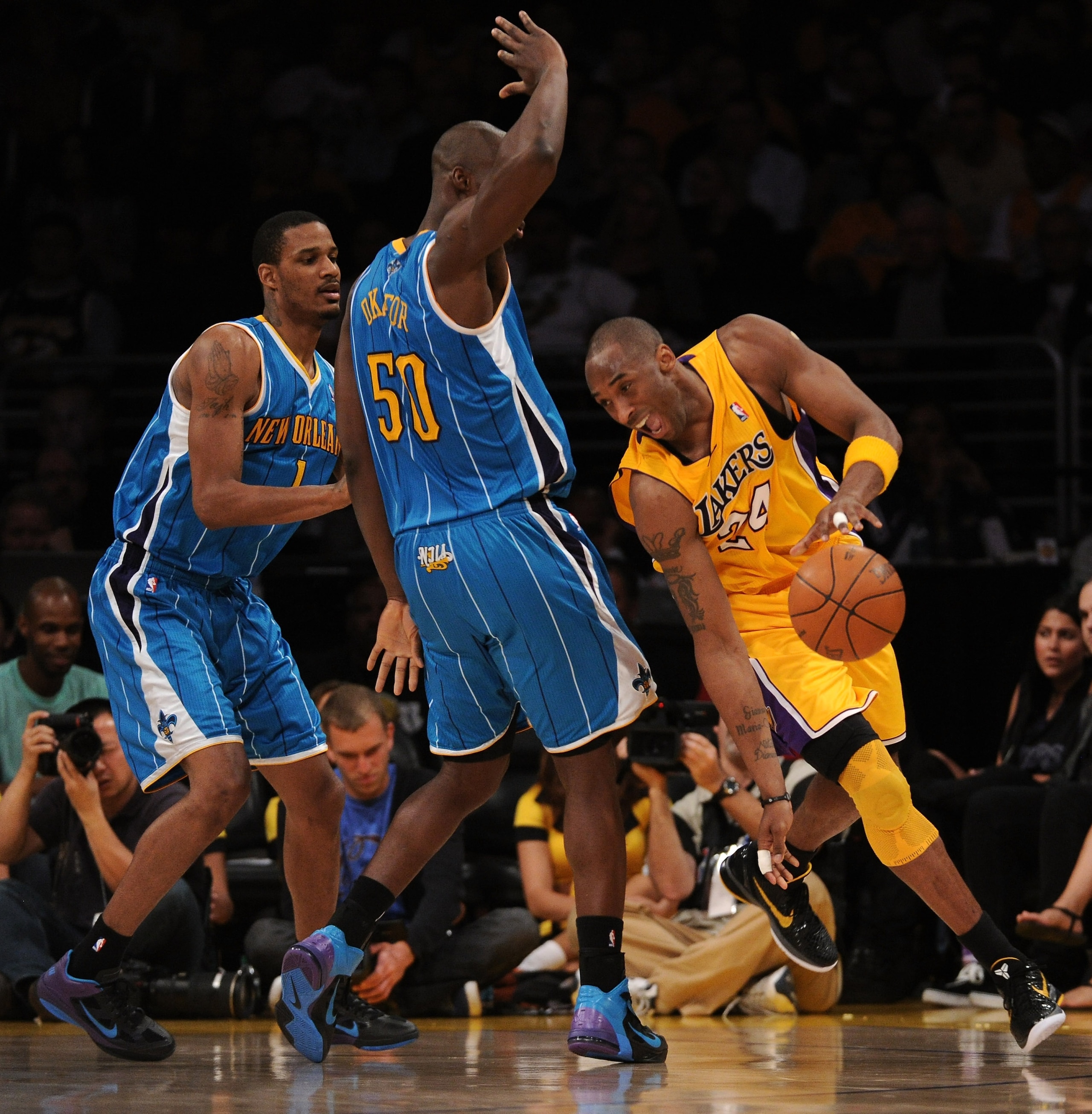 LOS ANGELES, CA - APRIL 26: Kobe Bryant #24 of the Los Angeles Lakers drives around Emeka Okafor #50 and Trevor Ariza #1 of the New Orleans Hornets in the third quarter in Game Five of the Western Conference Quarterfinals in the 2011 NBA Playoffs on Apri LOS ANGELES, CA - APRIL 26: Kobe Bryant #24 of the Los Angeles Lakers drives around Emeka Okafor #50 and Trevor Ariza #1 of the New Orleans Hornets in the third quarter in Game Five of the Western Conference Quarterfinals in the 2011 NBA Playoffs on Apri