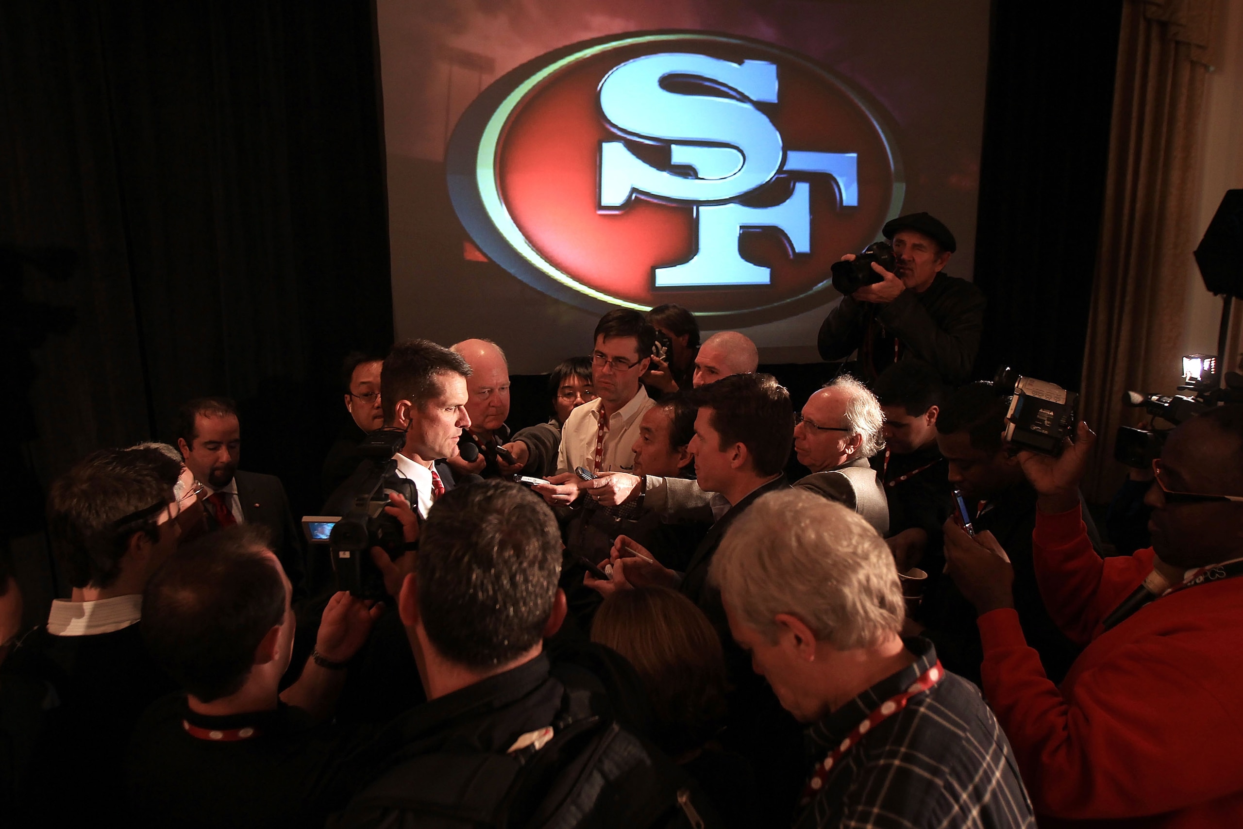 SAN FRANCISCO, CA - JANUARY 07: Jim Harbaugh is surrounded by media following a press conference where he was introduced as the new San Francisco 49ers head coach at the Palace Hotel on January 7, 2011 in San Francisco, California. (Photo by Ezra Shaw/G SAN FRANCISCO, CA - JANUARY 07: Jim Harbaugh is surrounded by media following a press conference where he was introduced as the new San Francisco 49ers head coach at the Palace Hotel on January 7, 2011 in San Francisco, California. (Photo by Ezra Shaw/G