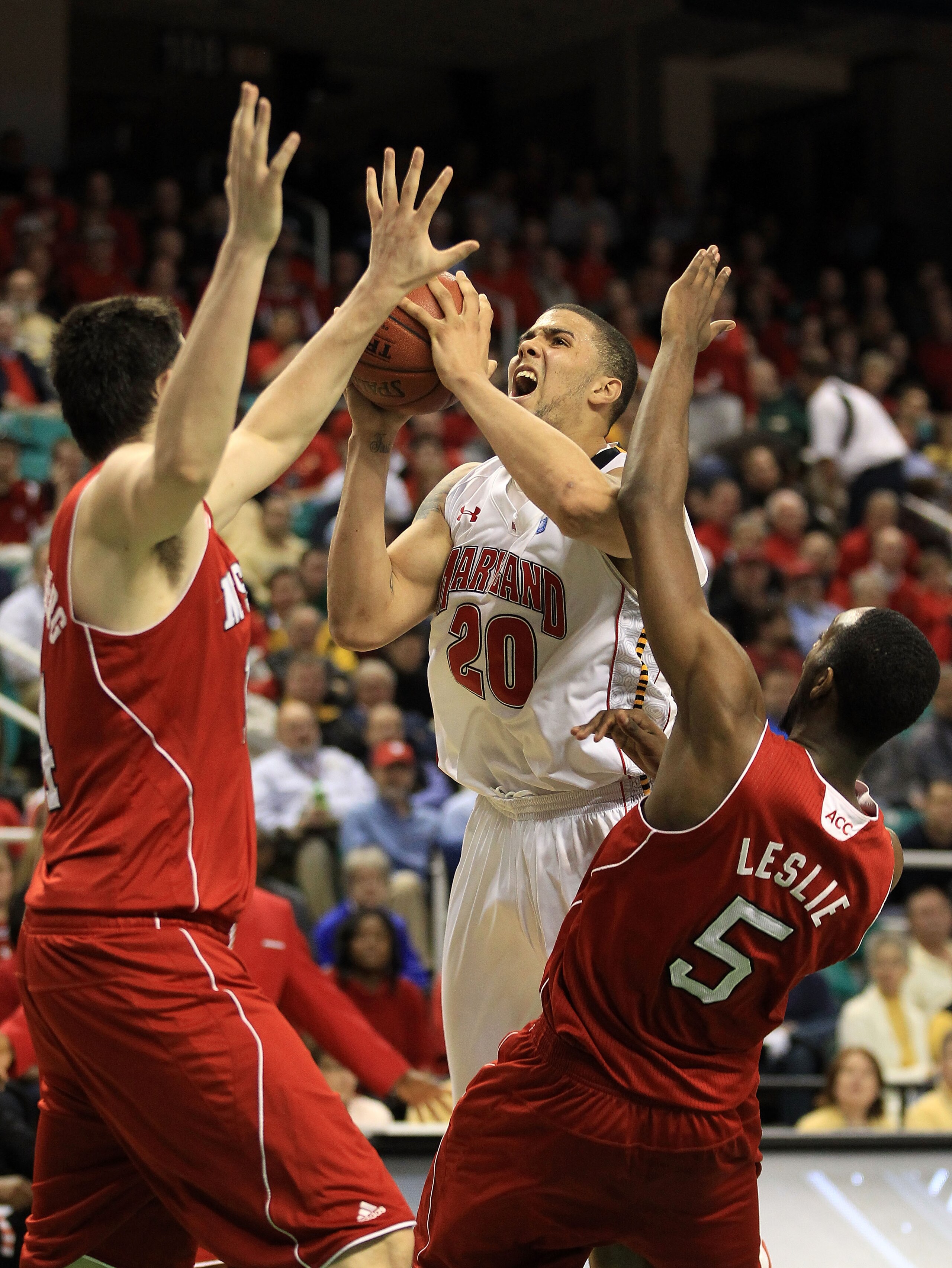 GREENSBORO, NC - MARCH 10:  Jordan Williams #20 of the Maryland Terrapins looks to shoot against Jordan Vandenberg #14 and C.J. Leslie #5 of the North Carolina State Wolfpack during the first round of the 2011 ACC men's basketball tournament at the Greens
