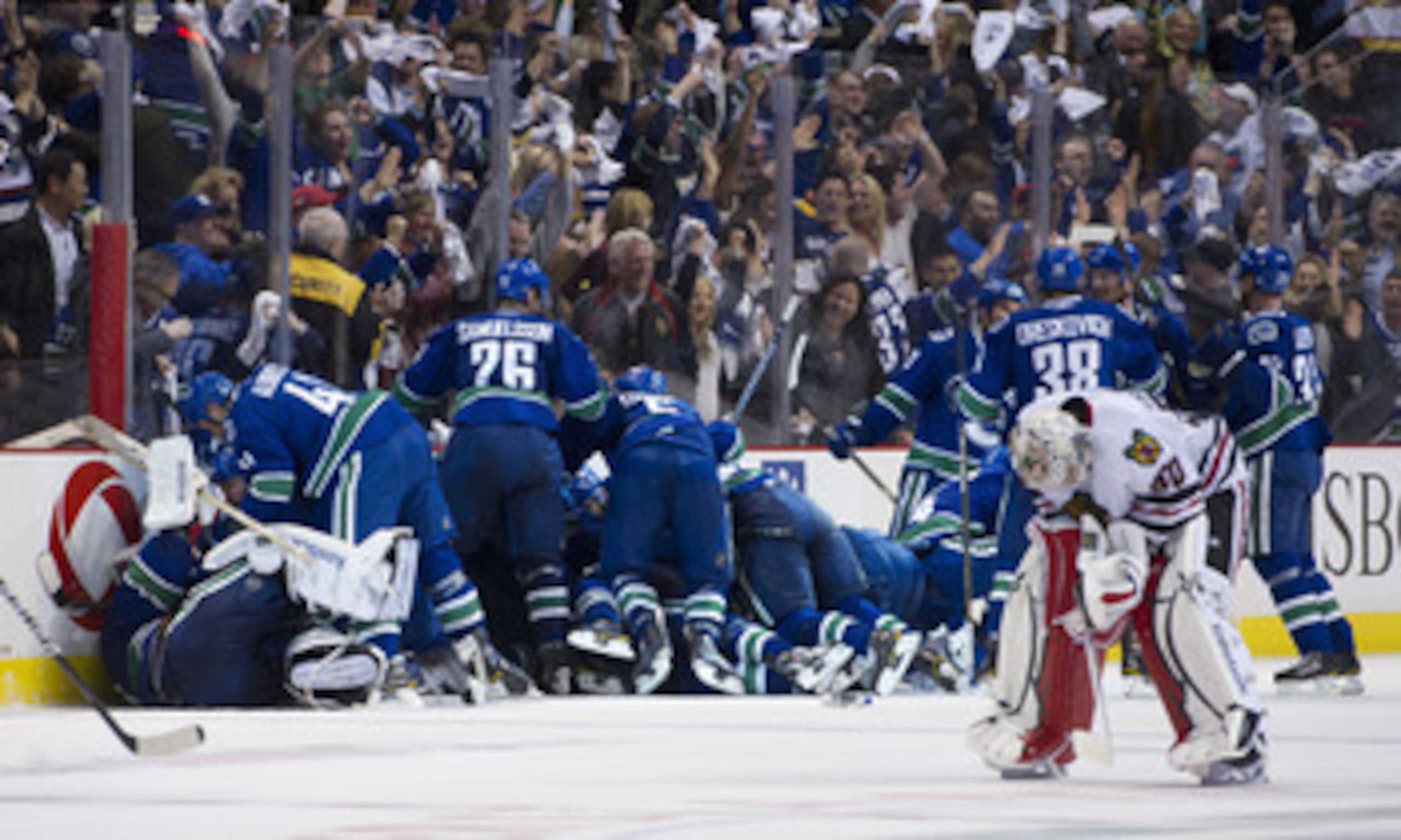 VANCOUVER, CANADA - APRIL 26: The Vancouver Canucks celebrate after defeating the Chicago Blackhawks 2-1 in overtime as goalie Corey Crawford #50 Chicago Blackhawks skates back to his after Game Seven of the Western Conference Quarterfinals during the 201