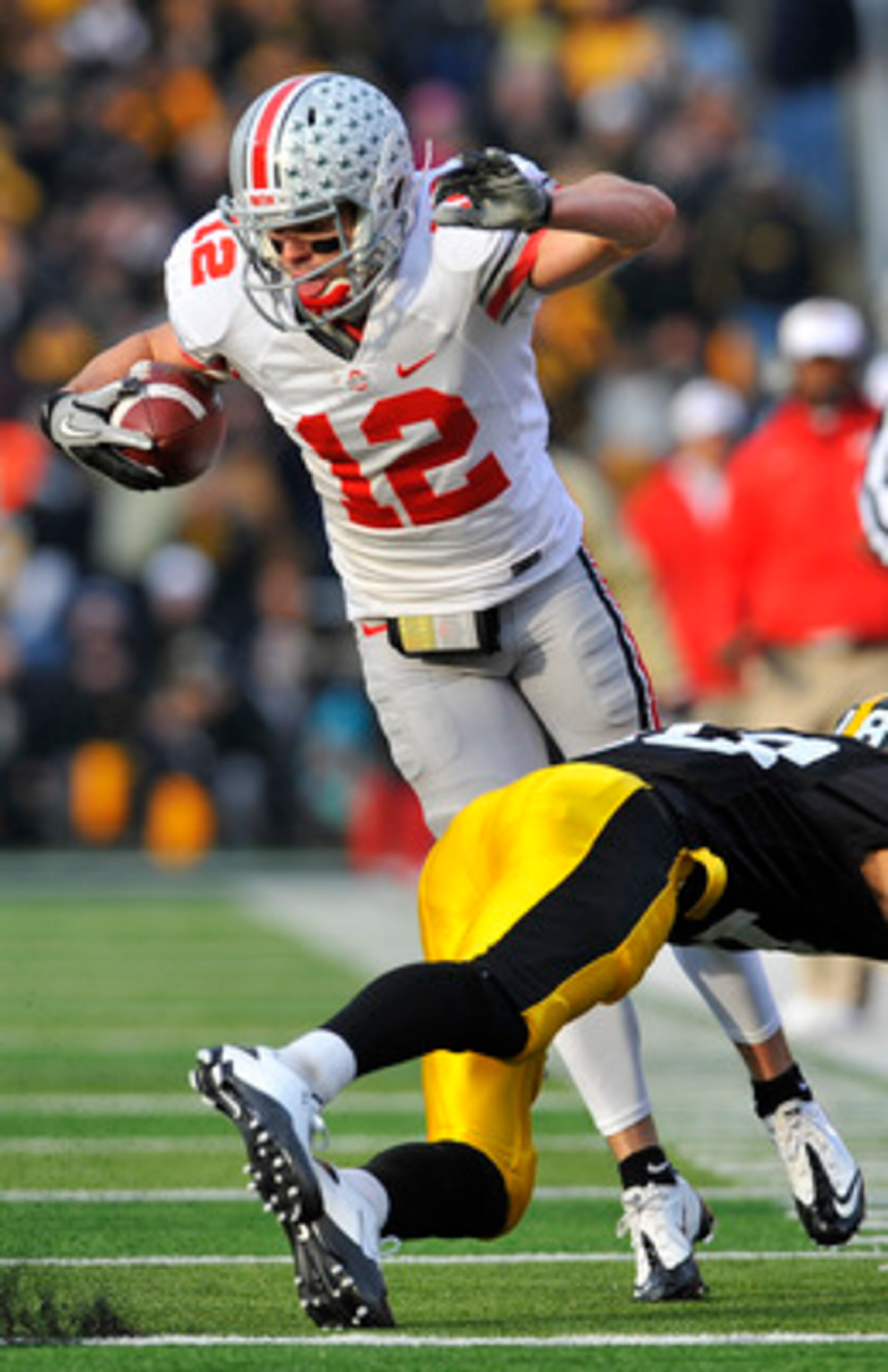 IOWA CITY, IA - NOVEMBER 20:  Defenisve back Micah Hyde #18 of the University of Iowa Hawkeyes trips up wide receiver Dane Sanzenbacher #12 of the Ohio State Buckeyes as he drove the ball down field during the first half of play at Kinnick Stadium on Nove