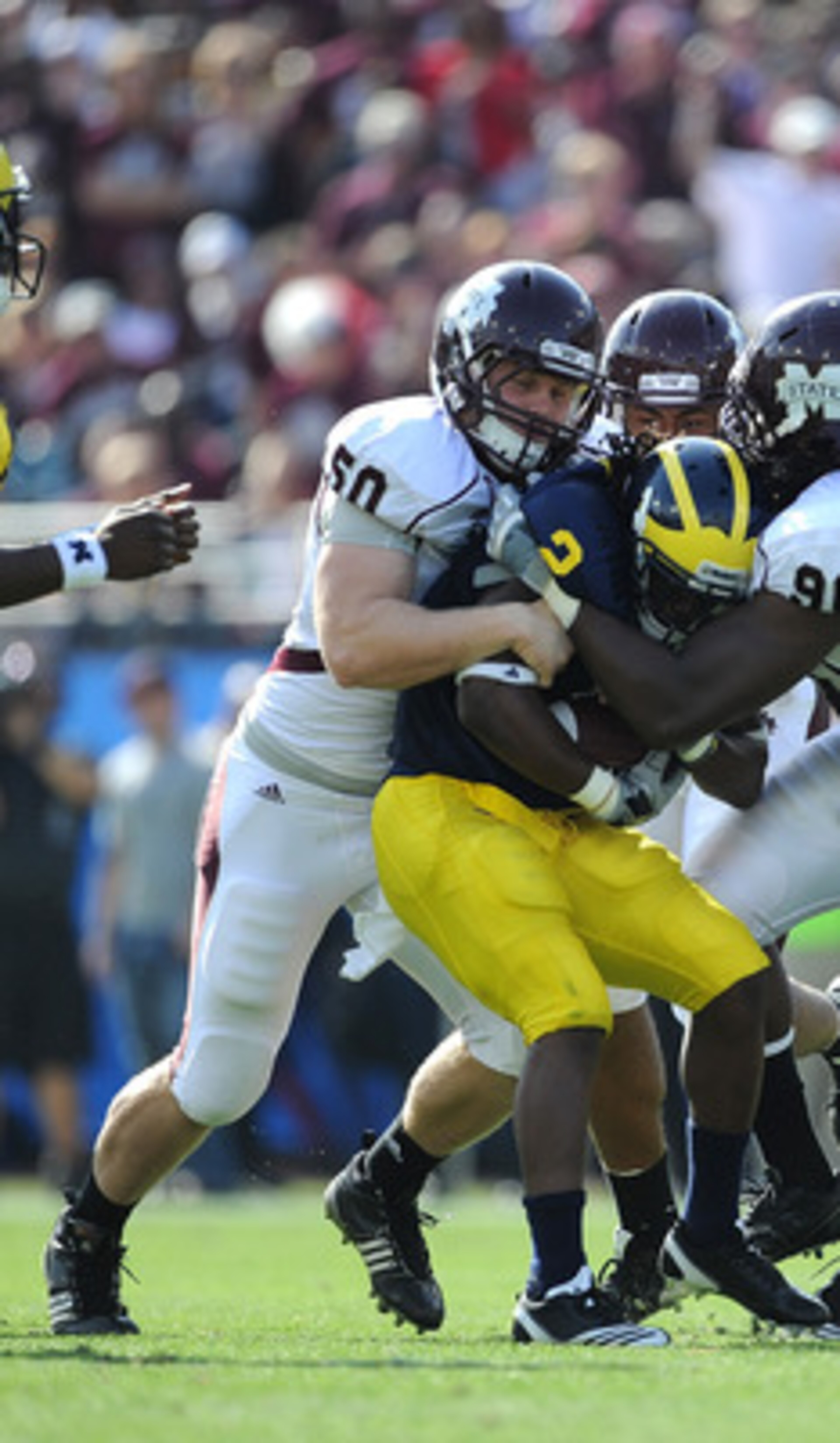 JACKSONVILLE, FL - JANUARY 01:  Chris White #50 and Pernell McPhee #90 of the Mississippi State Bulldogs tackle Vincent Smith # 2 of the Michigan Wolverines during the Gator Bowl at EverBank Field on January 1, 2011 in Jacksonville, Florida  (Photo by Ric