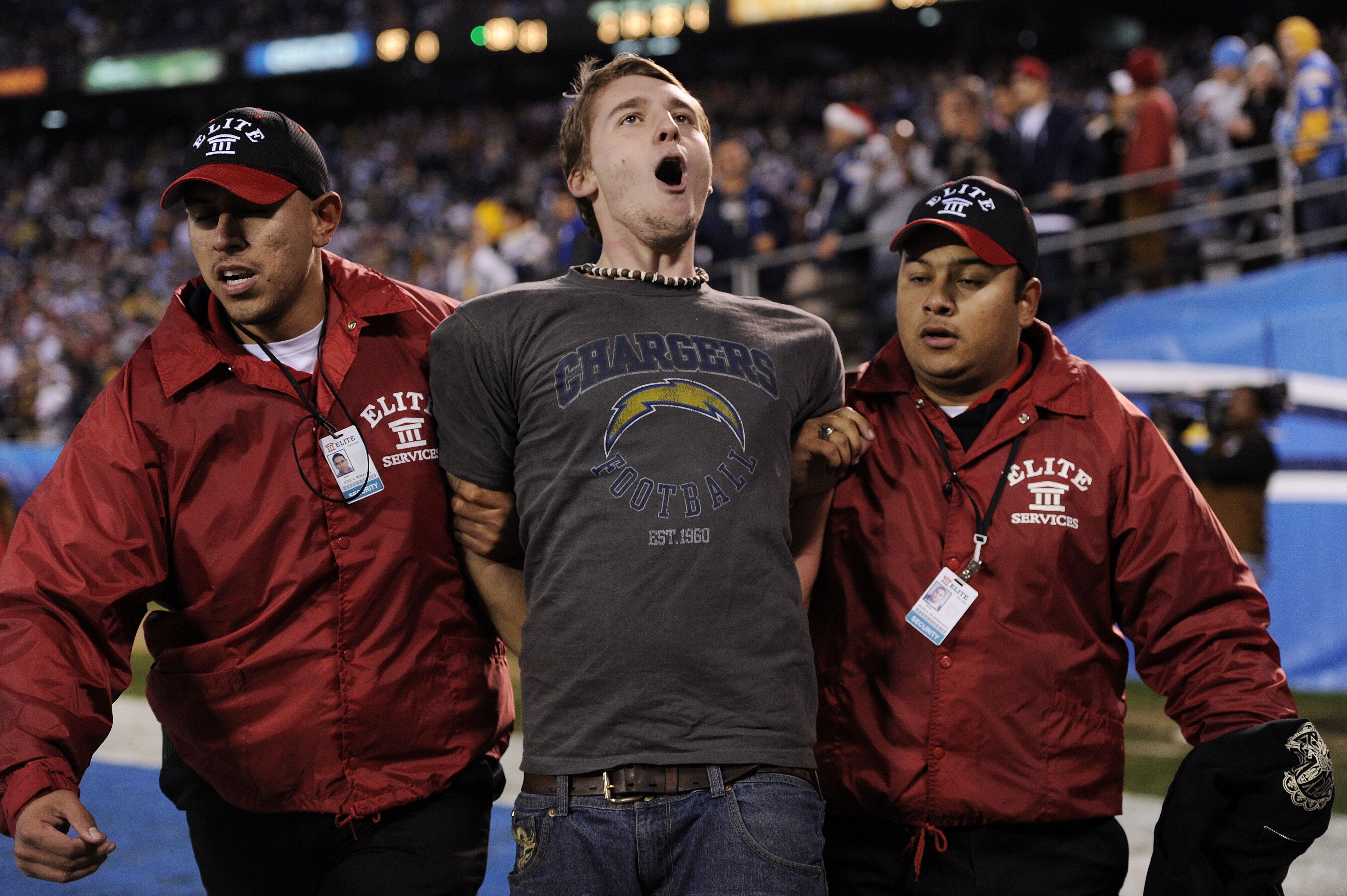 SAN DIEGO, CA - DECEMBER 16:  A fan is escorted away after running on the field during the game between the San Diego Chargers and the San Francisco 49ers at Qualcomm Stadium on December 16, 2010 in San Diego, California.  (Photo by Harry How/Getty Images