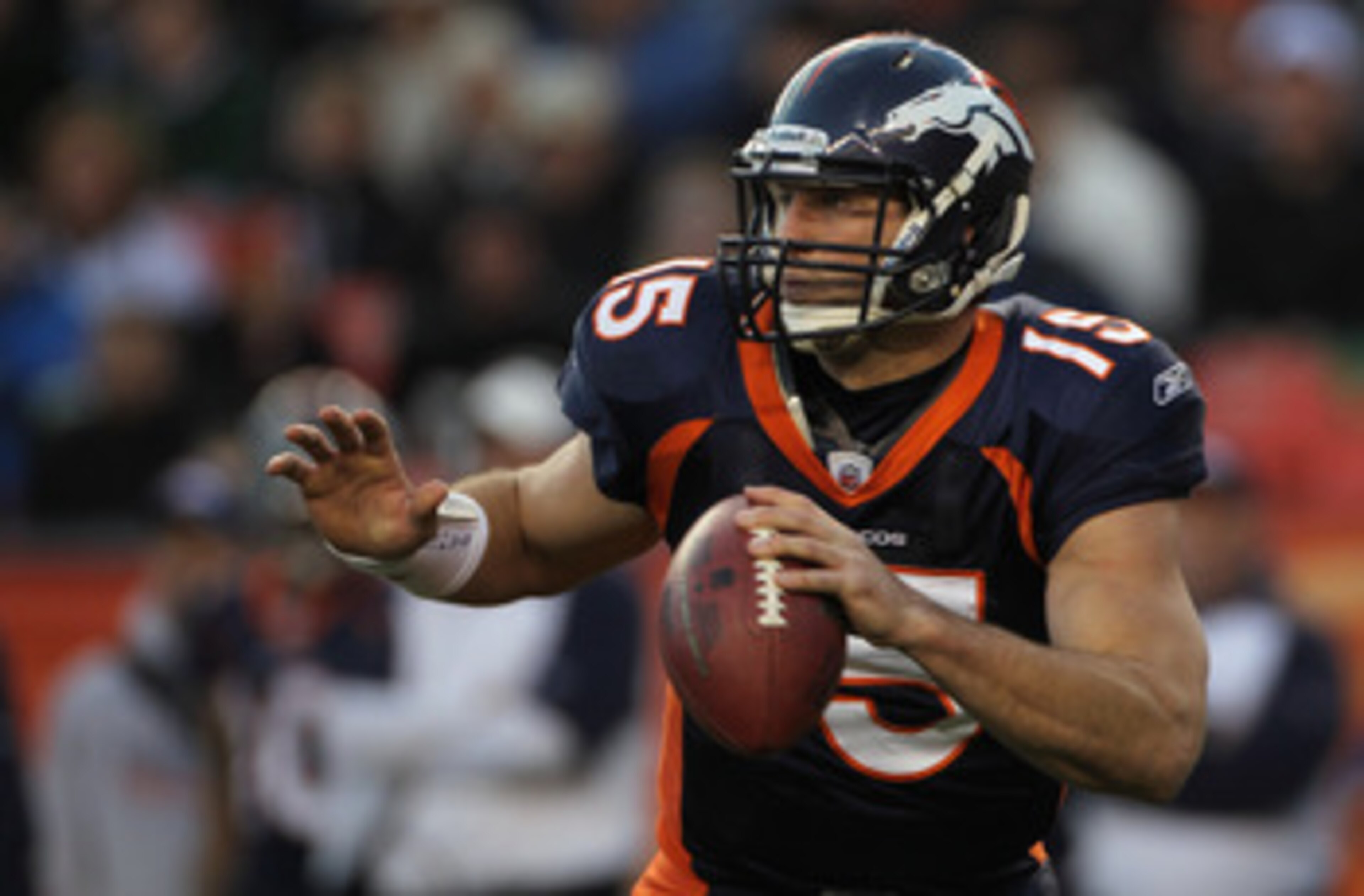 DENVER - DECEMBER 26:  Quarterback Tim Tebow #15 of the Denver Broncos rolls out and looks to deliver a pass against the Houston Texas at INVESCO Field at Mile High on December 26, 2010 in Denver, Colorado. The Broncos defeated the Texans 24-23.  (Photo b