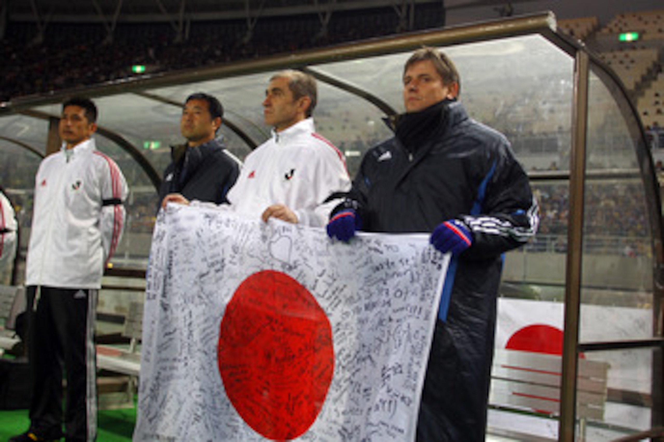 OSAKA, JAPAN - MARCH 29:  J.League XI 'Team As One' team coach, Dragan Stojkjovc holds a signed national flag of Japan  to show support to the earthquake victims prior to a charity match for those affected by the earthquake and tsunami at Nagai Stadium on