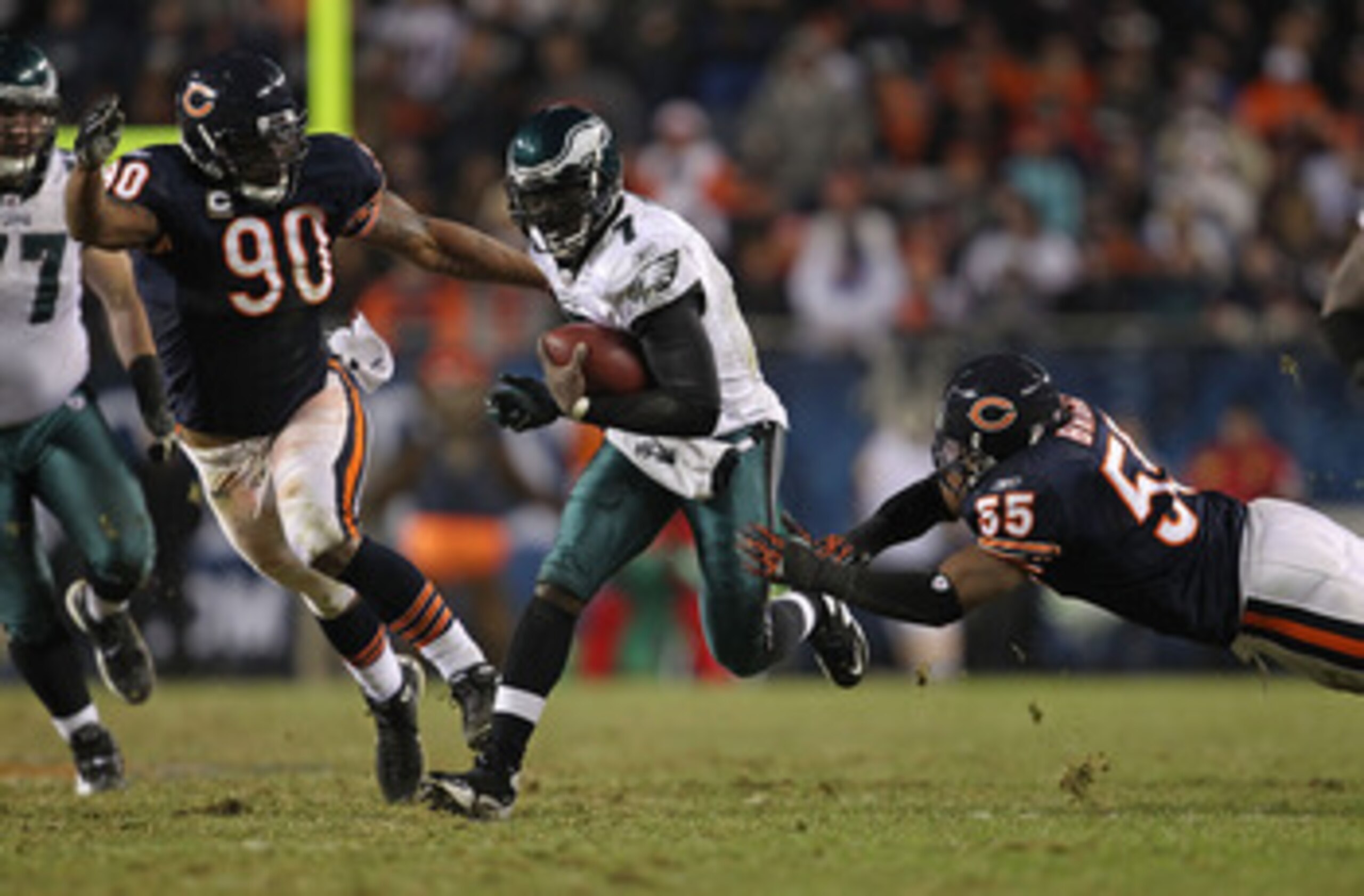 CHICAGO - NOVEMBER 28: Michael Vick #7 of the Philadelphia Eagles breaks a tackle by Lance Briggs #55 of the Chicago Bears as Julius Peppers #90 closes in at Soldier Field on November 28, 2010 in Chicago, Illinois. The Bears defeated the Eagles 31-26. (Ph