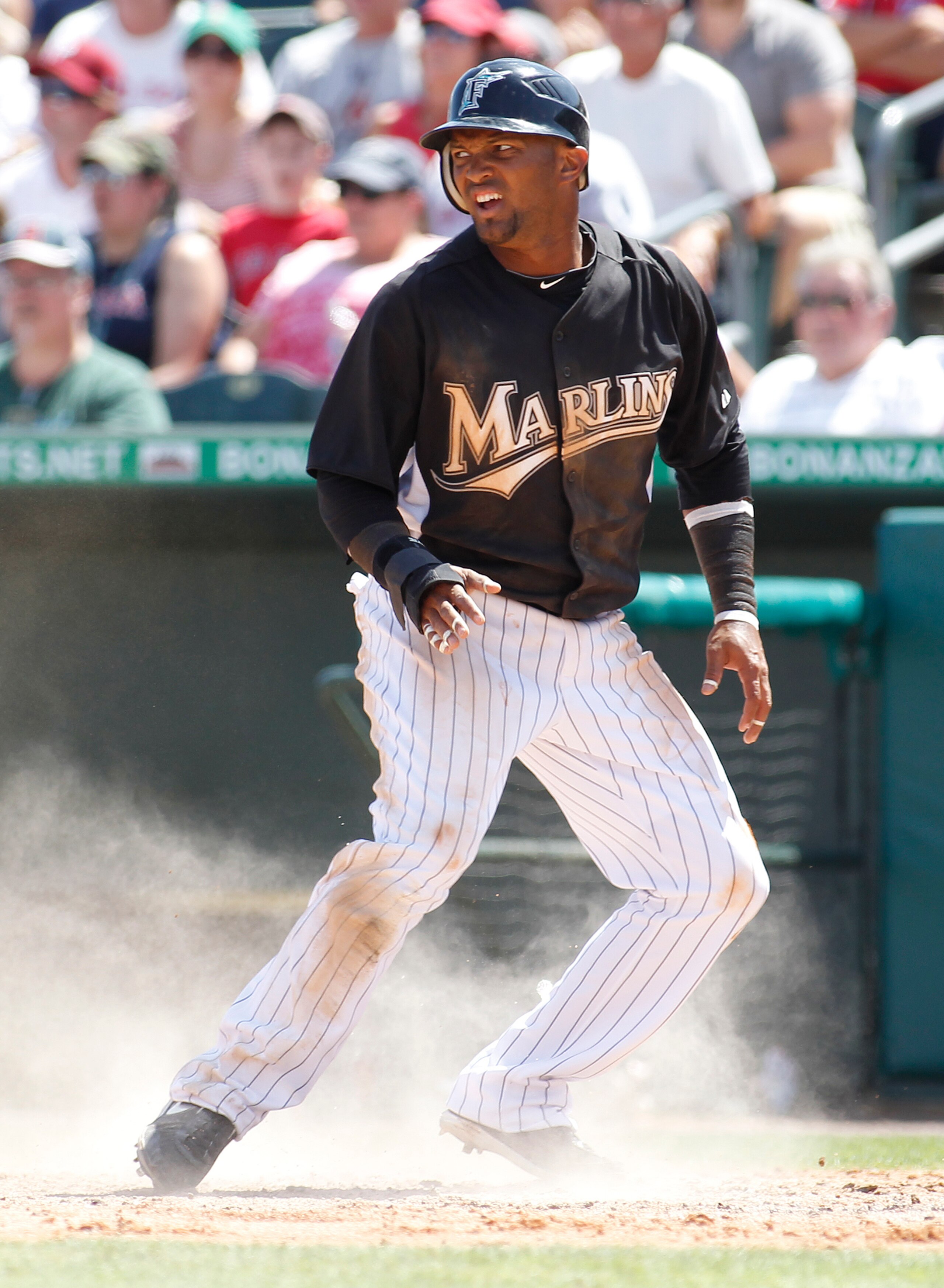 JUPITER, FL - MARCH 24: Emilio Bonifacio #1 of the Florida Marlins looks back towards the field after sliding home safe against the Boston Red Sox at Roger Dean Stadium on March 24, 2011 in Jupiter, Florida. (Photo by Joel Auerbach/Getty Images)