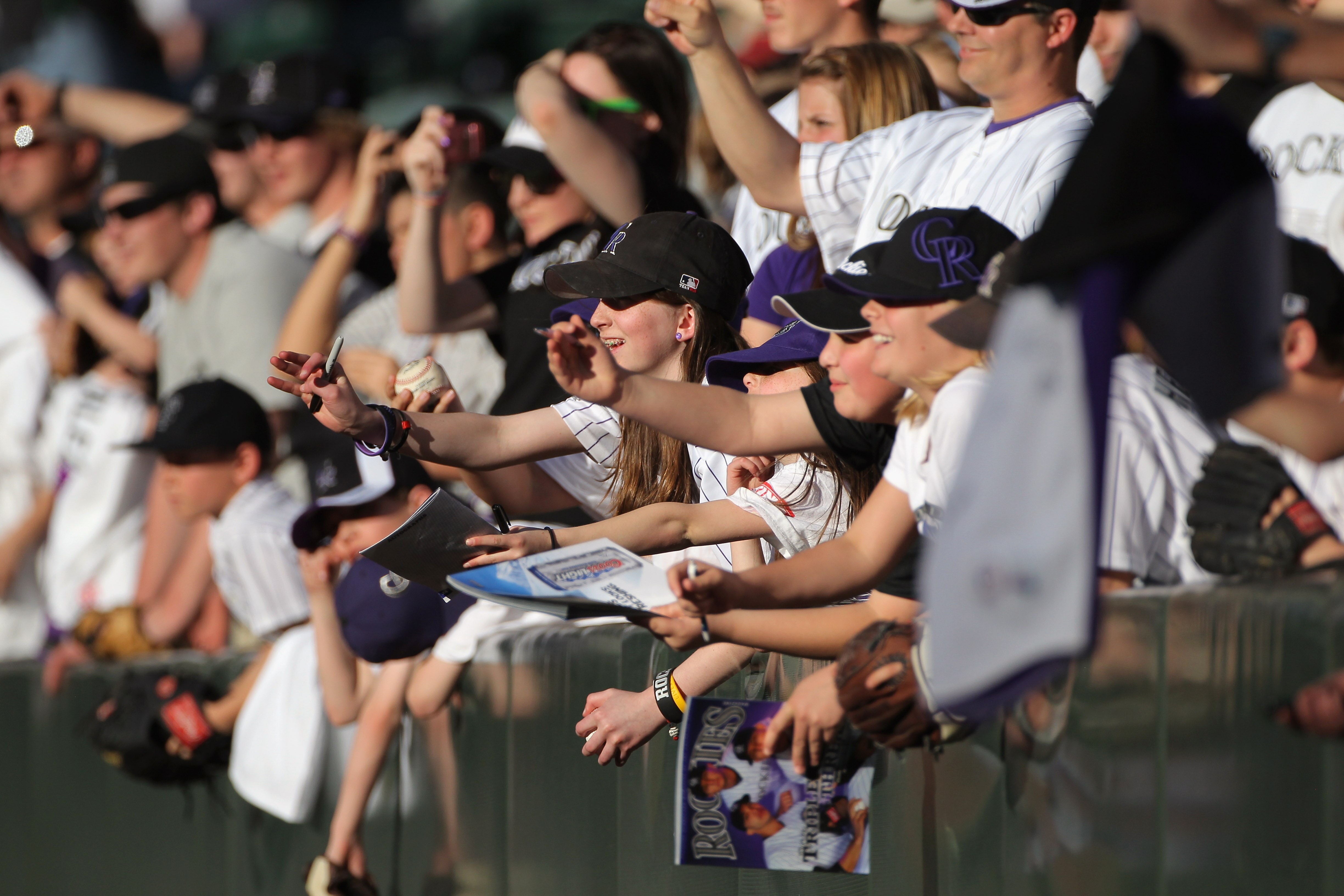DENVER, CO - APRIL 02:  Fans look to get autographs from players as the Colorado Rockies host the Arizona Diamondbacks at Coors Field on April 2, 2011 in Denver, Colorado.  (Photo by Doug Pensinger/Getty Images)