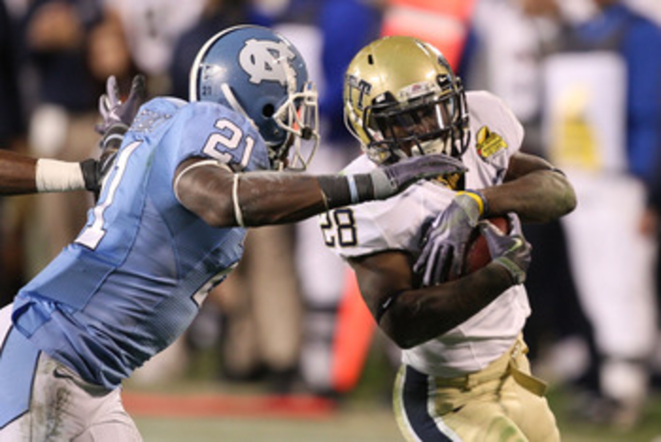 CHARLOTTE, NC - DECEMBER 26:  Dion Lewis #28 of the Pittsburgh Panthers tries to get away from Da'Norris Searcy #21 of the North Carolina Tar Heels during their game on December 26, 2009 in Charlotte, North Carolina.  (Photo by Streeter Lecka/Getty Images