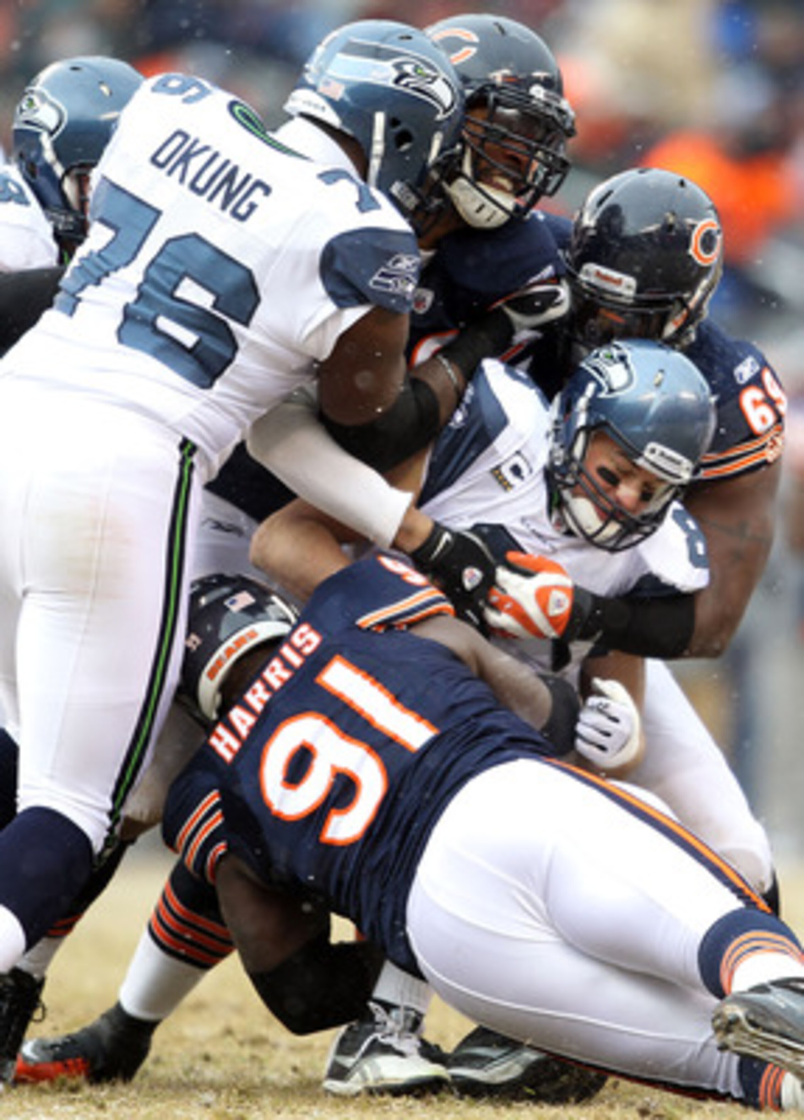 CHICAGO, IL - JANUARY 16:  Quarterback Matt Hasselbeck #8 of the Seattle Seahawks is sacked by three members of the Chicago Bears defense in the first half during the 2011 NFC divisional playoff game at Soldier Field on January 16, 2011 in Chicago, Illino