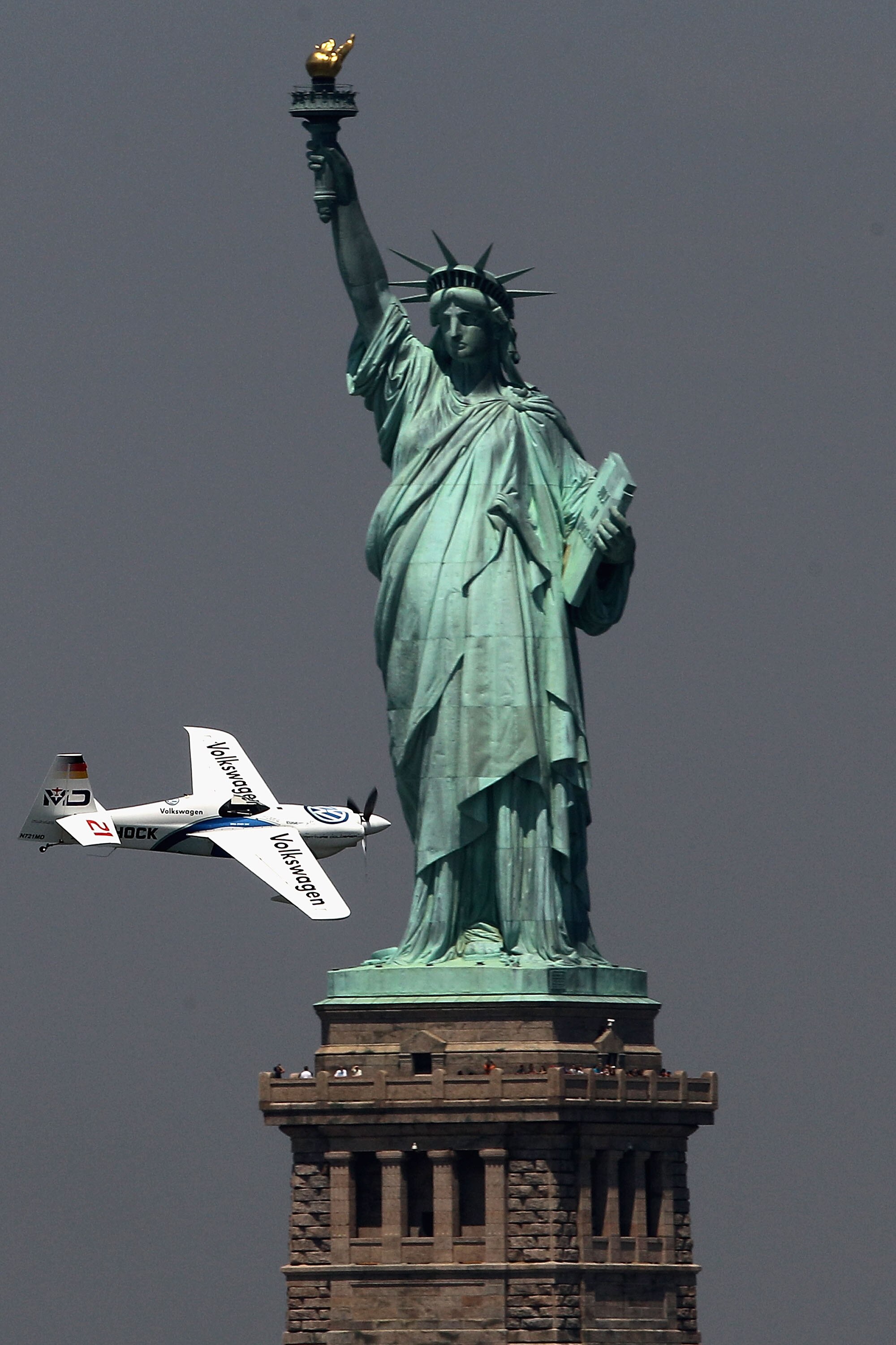 NEW YORK - JUNE 18:  Matthias Dolderer of Germany flies past the Statue of Liberty during the Red Bull Air Race New York Training Day on June 18, 2010 in New Jersey.  (Photo by Hamish Blair/Getty Images for Red Bull Air Race)