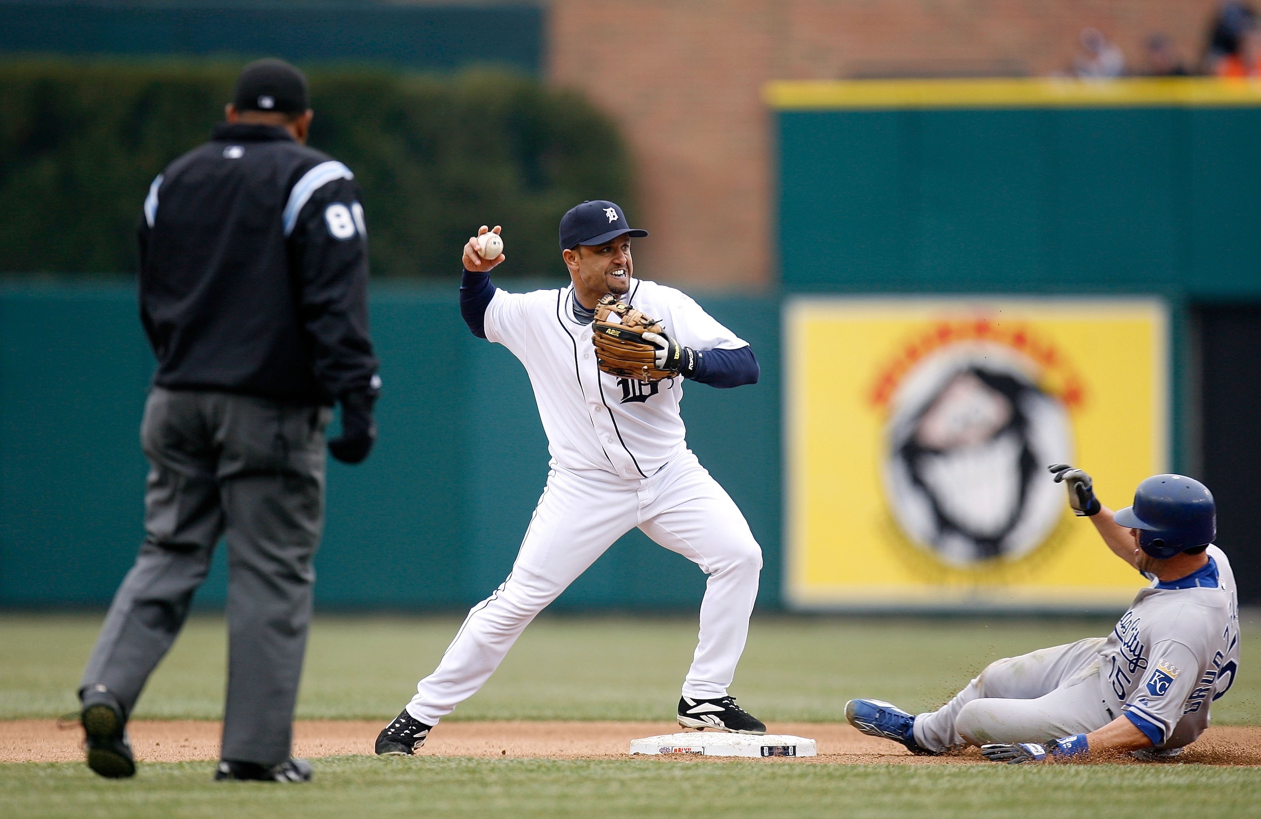 DETROIT - MARCH 31:  Placido Polanco #14 of the Detroit Tigers turns a double play against a sliding Mark Grudzielanek #15 of the Kansas City Royals during their game on Opening Day on March 31, 2008 at Comerica Park in Detroit, Michigan.  (Photo by Grego