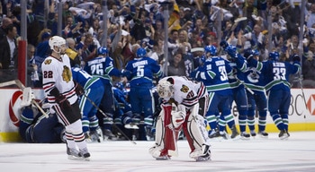 VANCOUVER, CANADA - APRIL 26: Troy Brouwer #22 of the Chicago Blackhawks skates towards goalie Corey Crawford #50 as the Vancouver Canucks celebrate after defeating the Blackhawks 2-1 in overtime of Game Seven of the Western Conference Quarterfinals durin