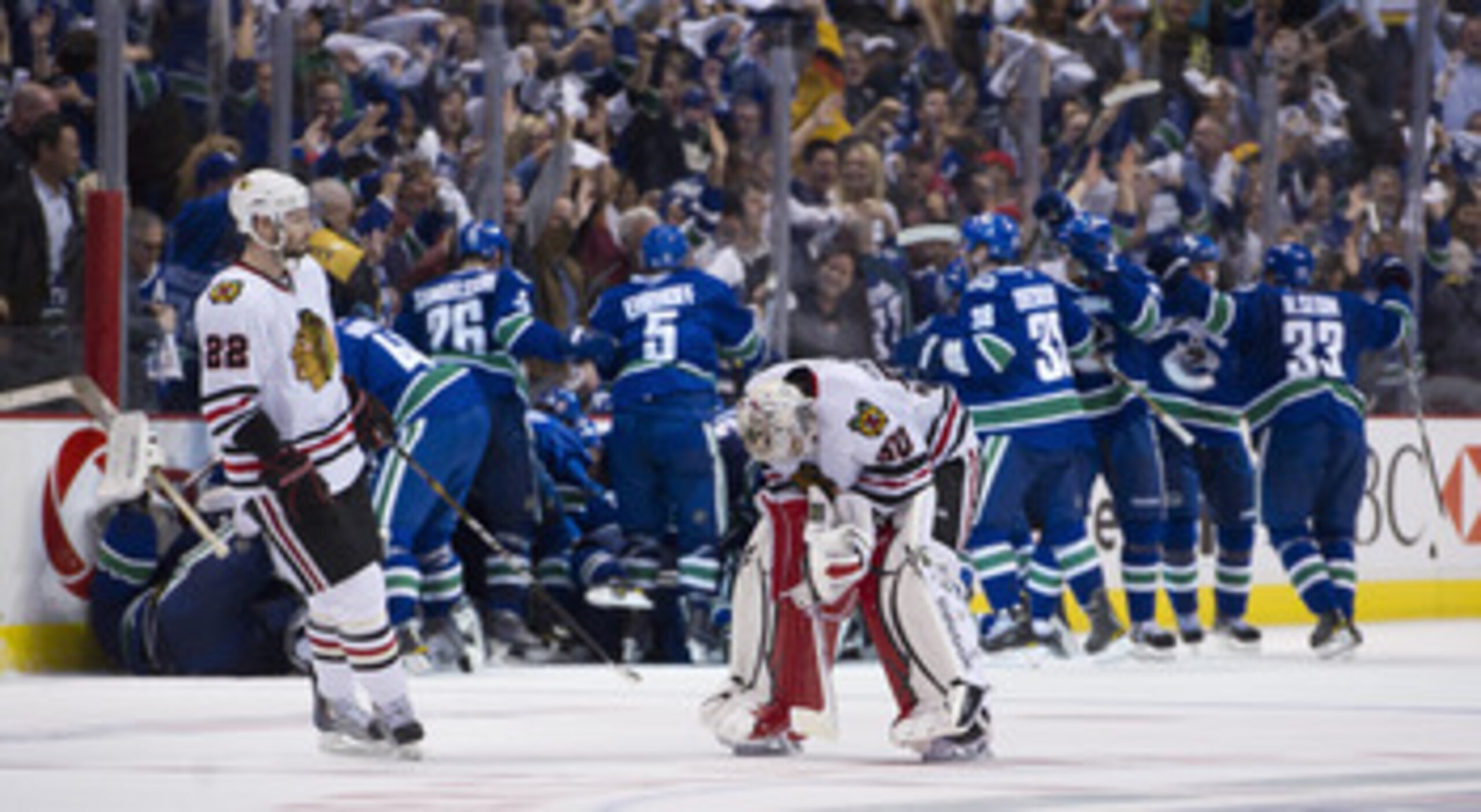 VANCOUVER, CANADA - APRIL 26: Troy Brouwer #22 of the Chicago Blackhawks skates towards goalie Corey Crawford #50 as the Vancouver Canucks celebrate after defeating the Blackhawks 2-1 in overtime of Game Seven of the Western Conference Quarterfinals durin