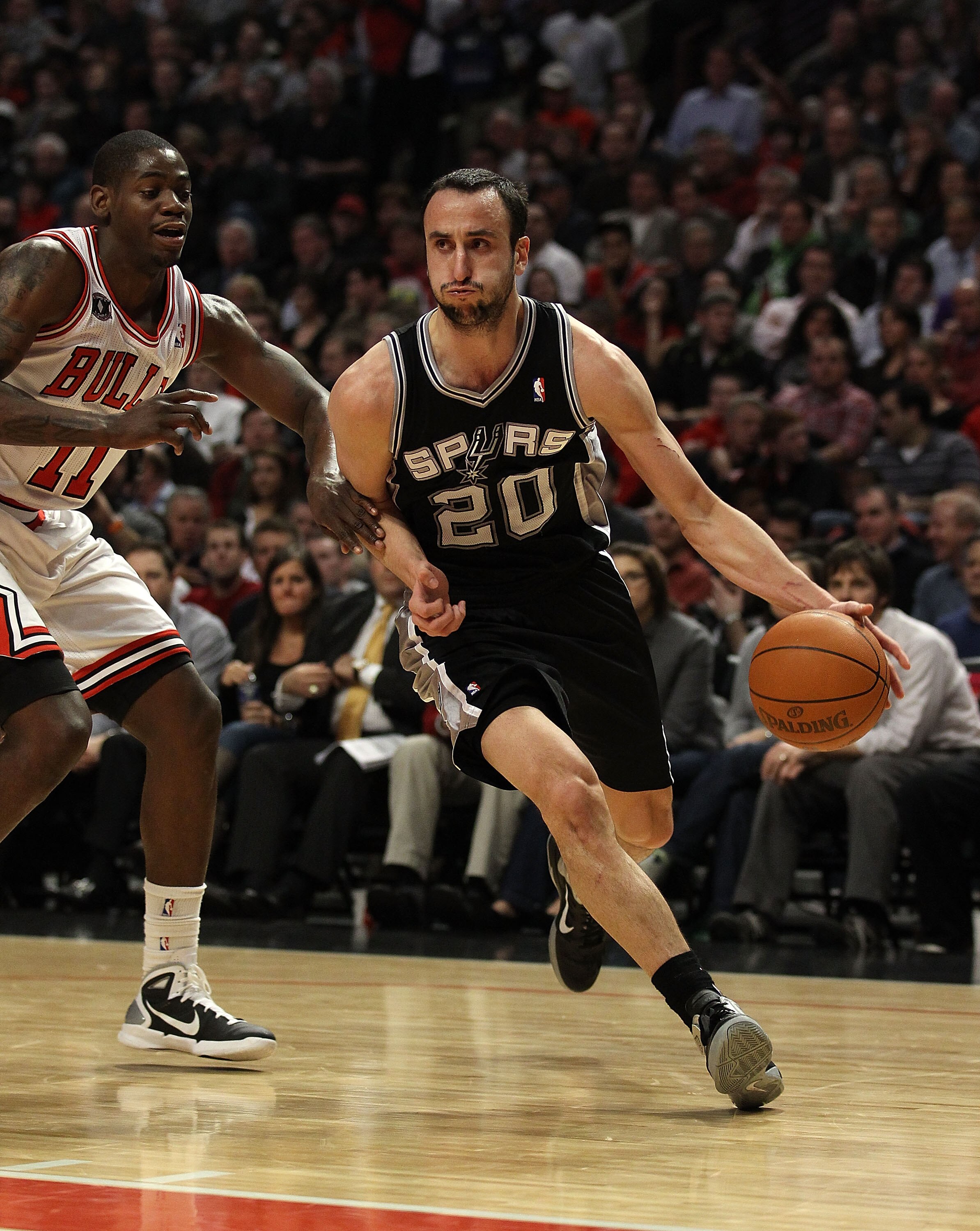 CHICAGO, IL - FEBRUARY 17: Manu Ginobili #20 of the San Antonio Spurs moves past Ronnie Brewer #11 of the Chicago Bulls at the United Center on February 17, 2011 in Chicago, Illinois. The Bulls defeated the Spurs 109-99. NOTE TO USER: User expressly ackno
