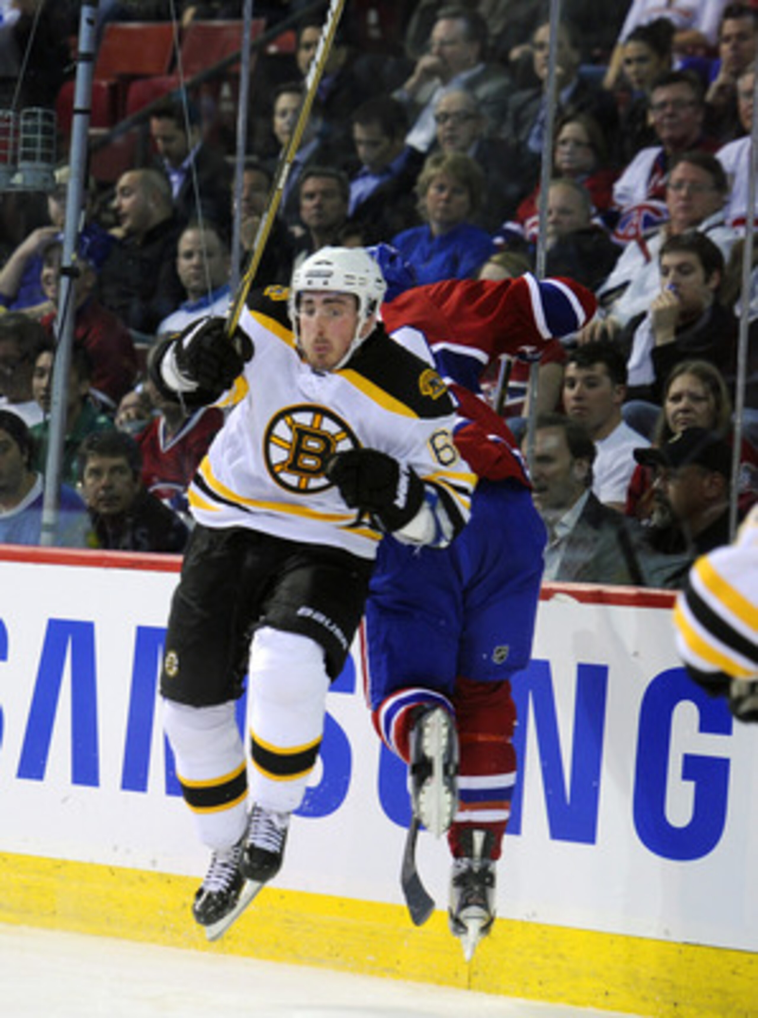 MONTREAL, CANADA - APRIL 26: Brad Marchand #63 of the Boston Bruins throws a bodycheck on Travis Moen #32 of the Montreal Canadiens in behind the net in Game Six of the Eastern Conference Quarterfinals during the 2011 NHL Stanley Cup Playoffs at the Bell MONTREAL, CANADA - APRIL 26: Brad Marchand #63 of the Boston Bruins throws a bodycheck on Travis Moen #32 of the Montreal Canadiens in behind the net in Game Six of the Eastern Conference Quarterfinals during the 2011 NHL Stanley Cup Playoffs at the Bell