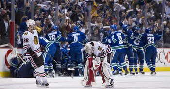 VANCOUVER, CANADA - APRIL 26: Troy Brouwer #22 of the Chicago Blackhawks skates towards goalie Corey Crawford #50 as the Vancouver Canucks celebrate after defeating the Blackhawks 2-1 in overtime of Game Seven of the Western Conference Quarterfinals durin