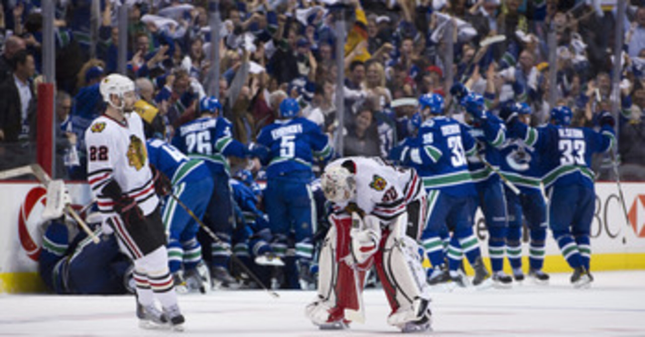 VANCOUVER, CANADA - APRIL 26: Troy Brouwer #22 of the Chicago Blackhawks skates towards goalie Corey Crawford #50 as the Vancouver Canucks celebrate after defeating the Blackhawks 2-1 in overtime of Game Seven of the Western Conference Quarterfinals durin VANCOUVER, CANADA - APRIL 26: Troy Brouwer #22 of the Chicago Blackhawks skates towards goalie Corey Crawford #50 as the Vancouver Canucks celebrate after defeating the Blackhawks 2-1 in overtime of Game Seven of the Western Conference Quarterfinals durin